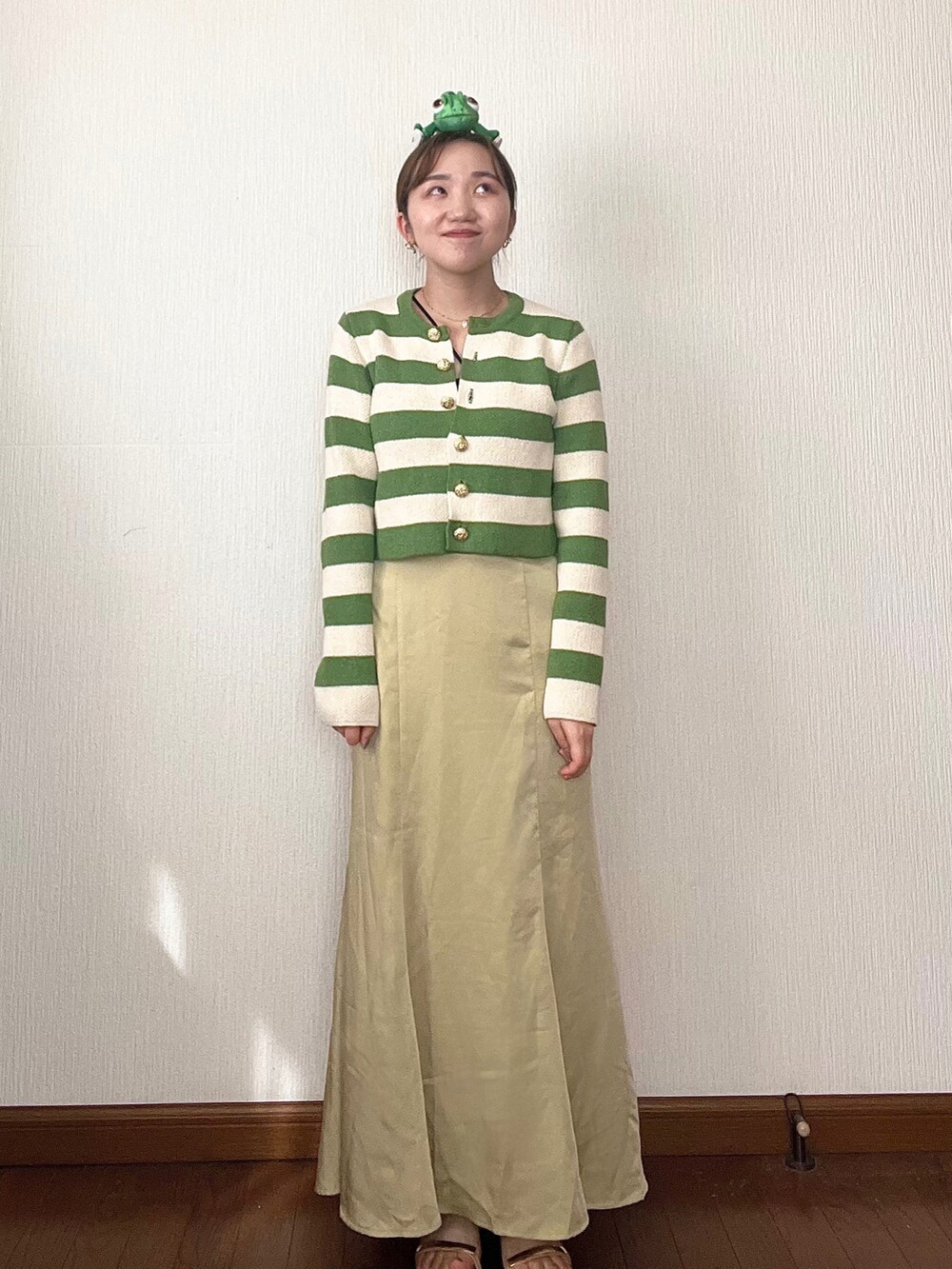 イエロー系のスカート、グリーン系のカーディガン/ボレロ、ベージュ系のサンダルを着用したレディースの秋コーディネートの4枚目の写真