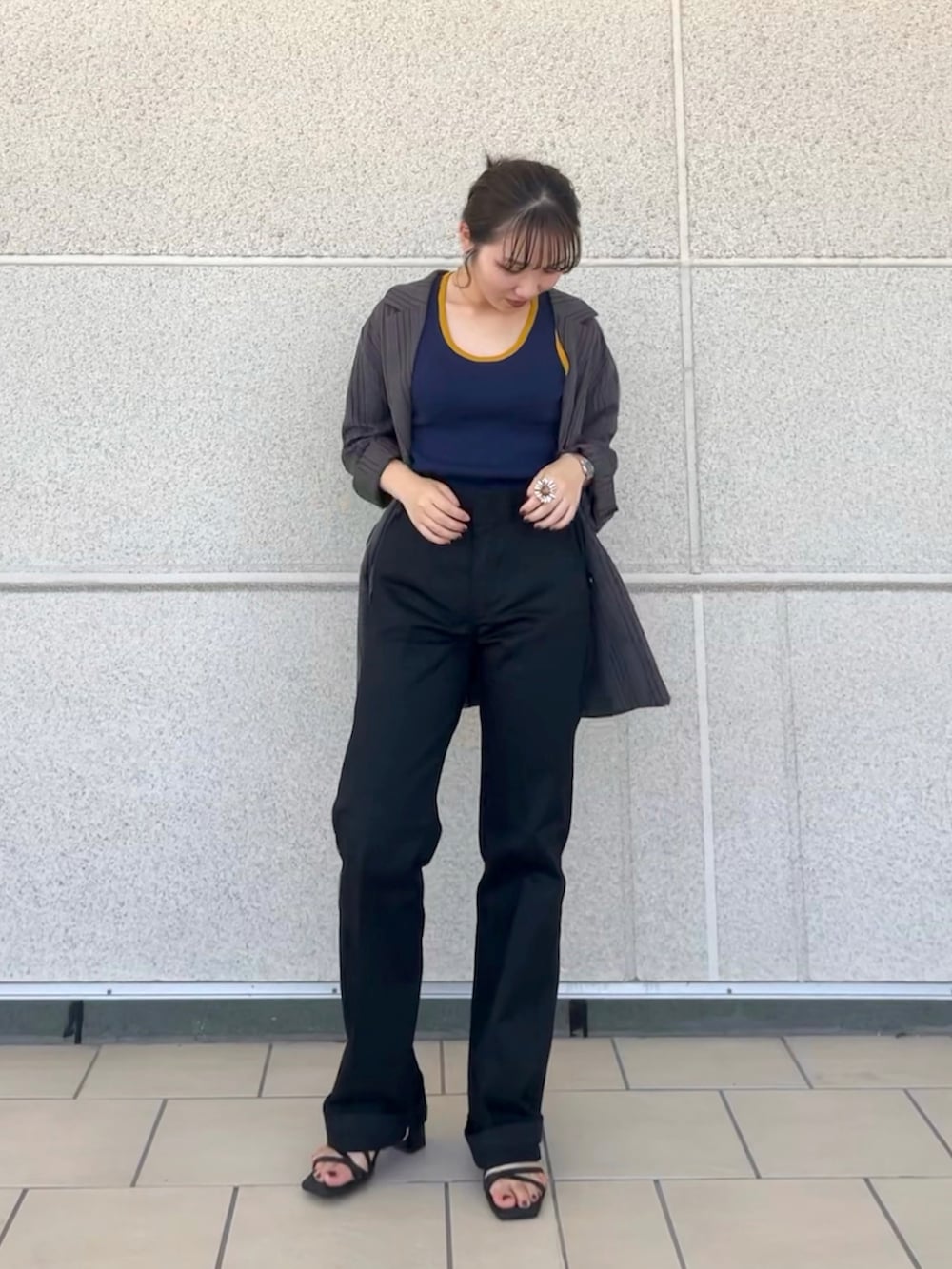 ブラック系のチノパンツ、ブルー系のタンクトップ、ブラック系のサンダルを着用したレディースの秋コーディネートの3枚目の写真