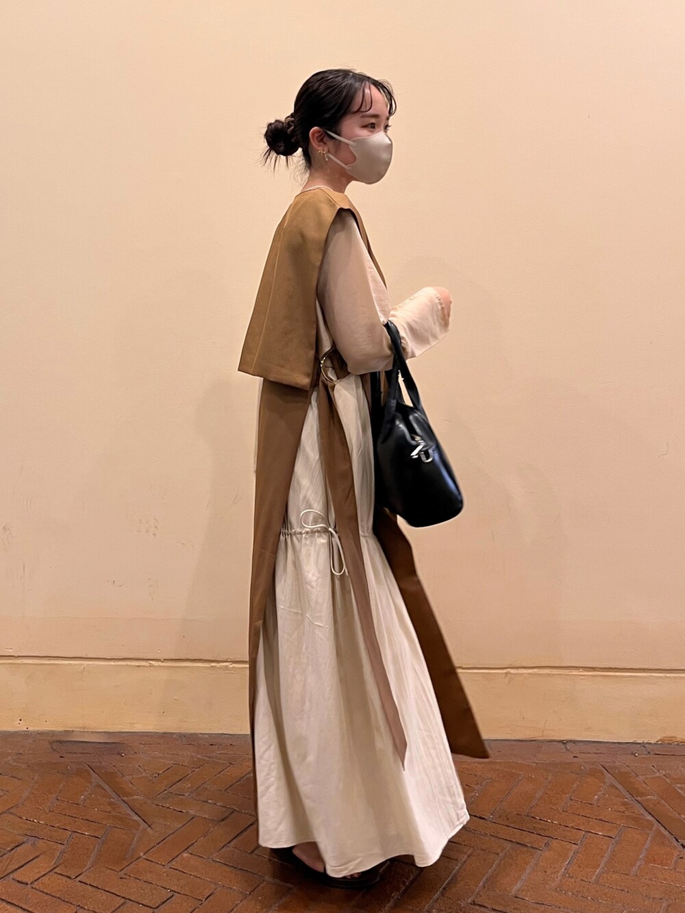 ブラウン系のワンピース、ベージュ系のTシャツ/カットソー、ホワイト系のスカートを着用したレディースの秋コーディネートの3枚目の写真