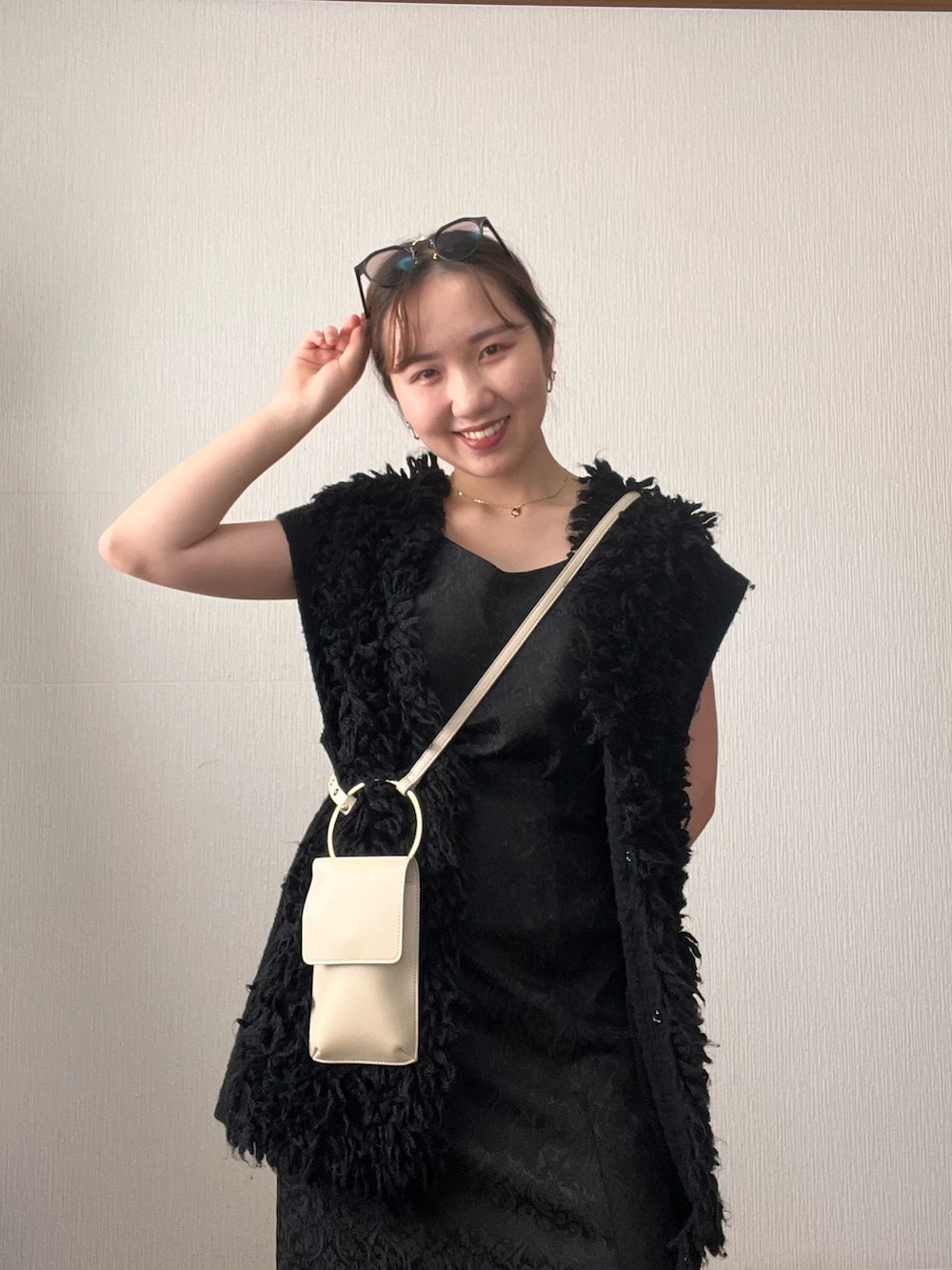 ブラック系のベスト、ブラック系のスカート、ブラック系のサンダルを着用したレディースの秋コーディネートの4枚目の写真