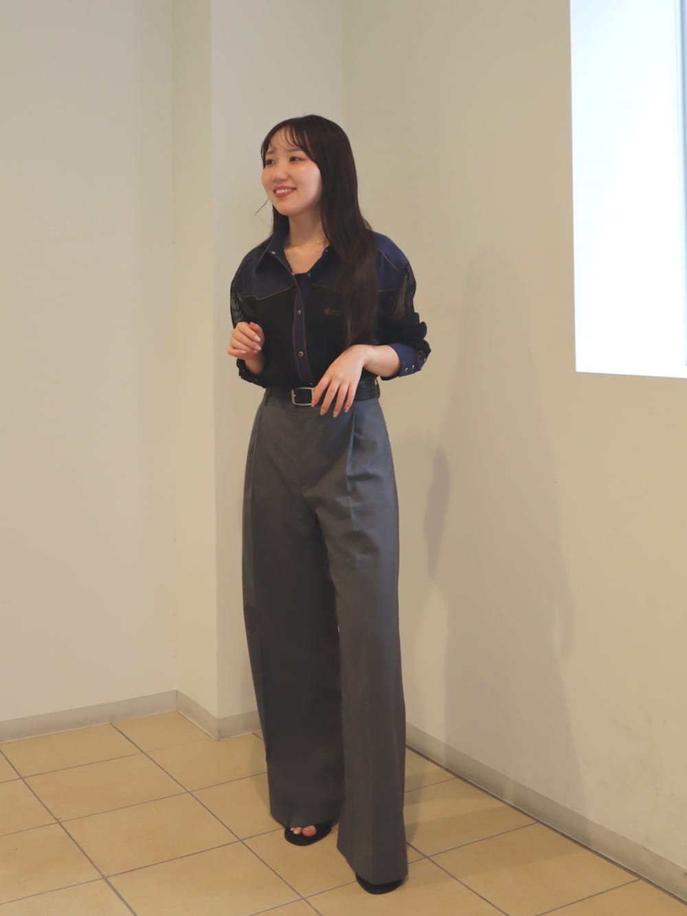 ブラック系のシャツ/ブラウス、グレー系のスラックス、ブラック系のサンダルを着用したレディースの夏コーディネートの3枚目の写真