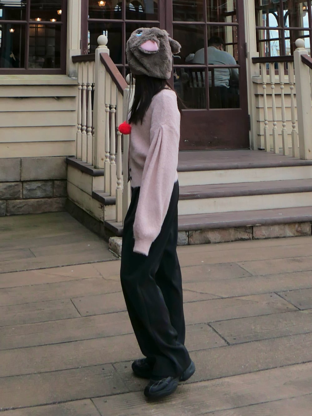 ピンク系のカーディガン/ボレロ、グレー系のその他パンツ、ブラック系のスニーカーを着用したレディースの冬コーディネートの2枚目の写真