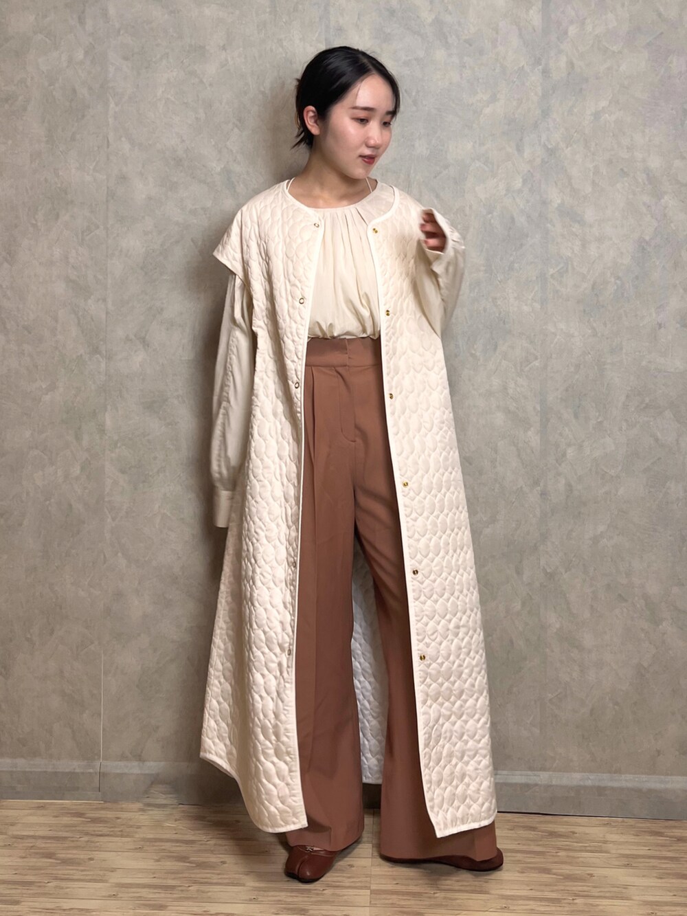 ブラウン系のスラックス、ホワイト系のシャツ/ブラウス、ホワイト系のベストを着用したレディースの秋コーディネートの2枚目の写真