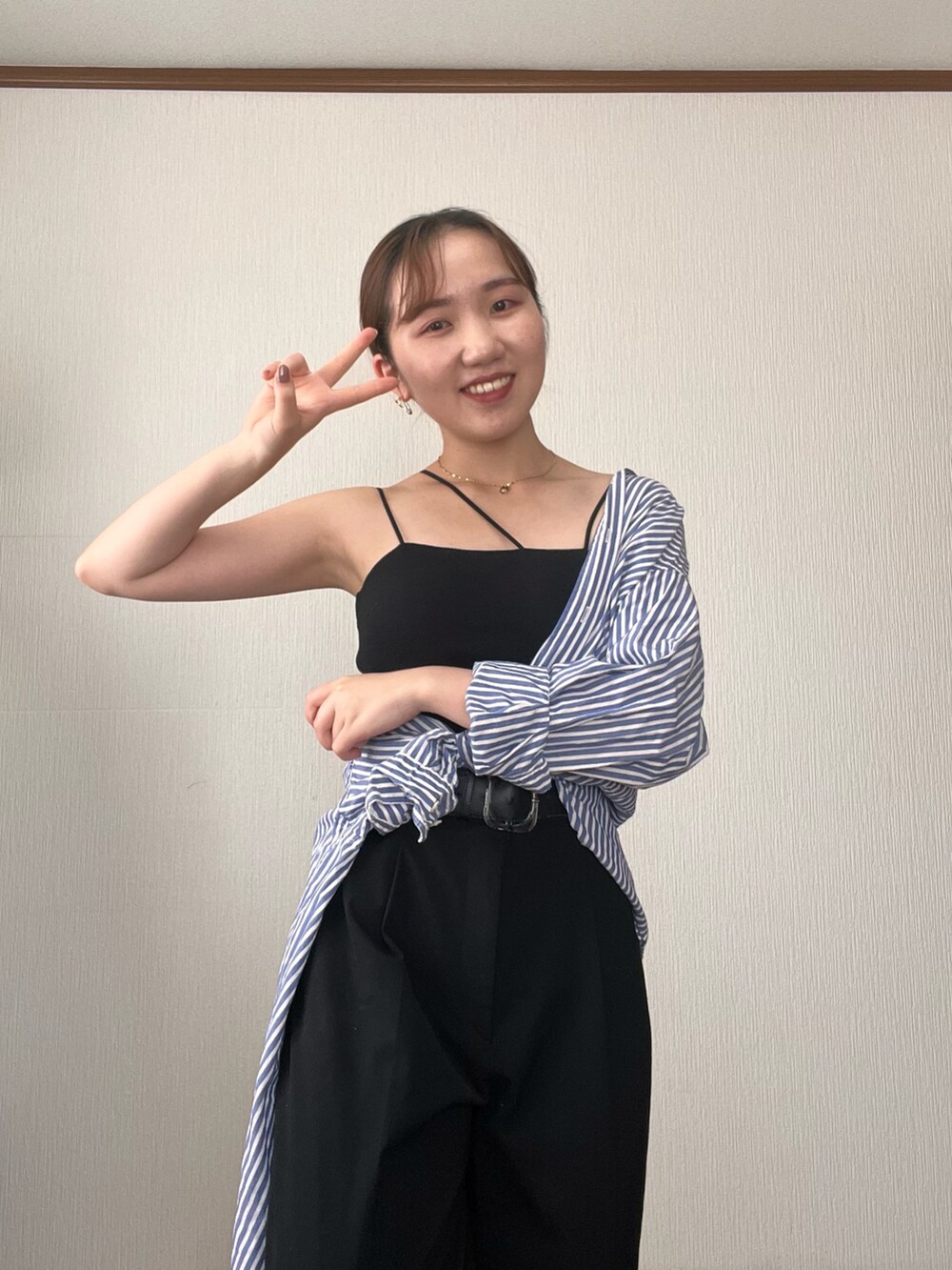 ブルー系のシャツ/ブラウス、ブラック系のデニムパンツ、ブラック系のサンダルを着用したレディースの秋コーディネートの3枚目の写真