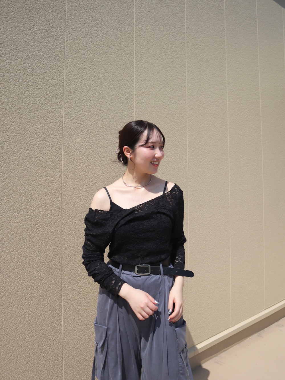 ブラック系のTシャツ/カットソー、グレー系のカーゴパンツ、ホワイト系のスニーカーを着用したレディースの夏コーディネートの3枚目の写真