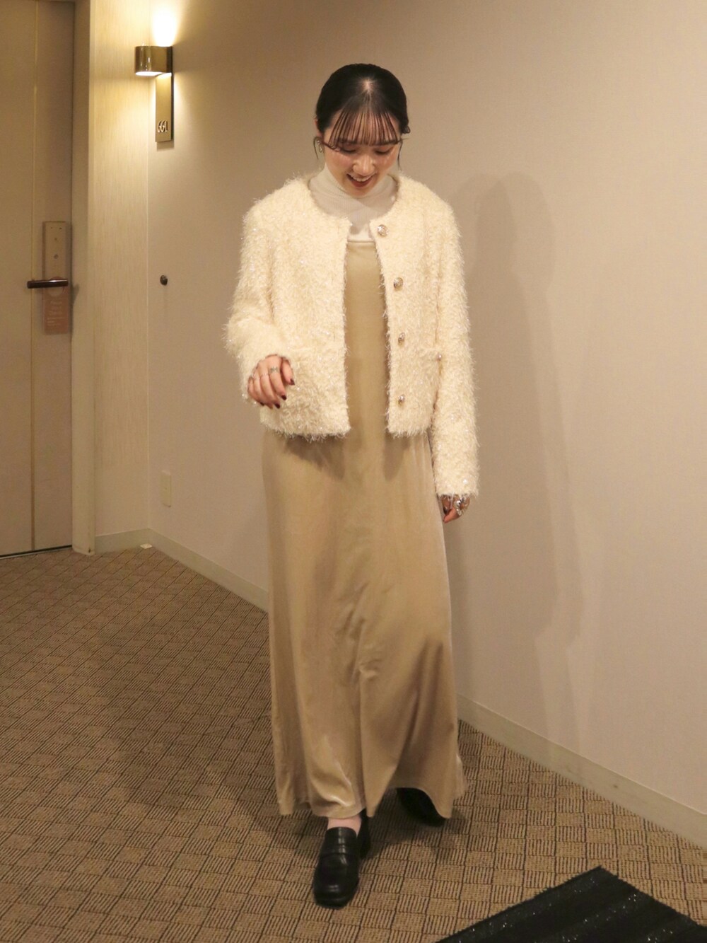 ベージュ系のワンピース、ホワイト系のニット/セーター、ホワイト系のノーカラージャケットを着用したレディースの冬コーディネートの2枚目の写真