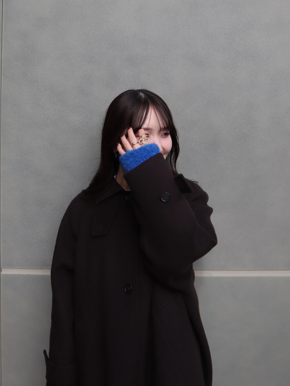 ブラック系のブーツ、ブルー系のカーディガン/ボレロ、ブラウン系のステンカラーコートを着用したレディースの秋コーディネートの4枚目の写真