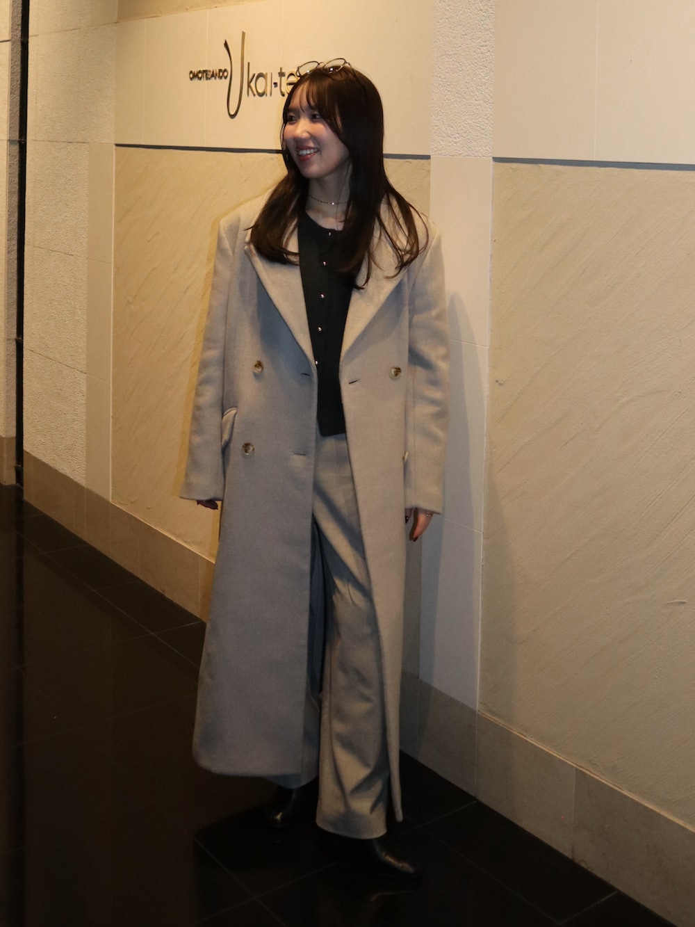 ブラック系のブーツ、ベージュ系のその他パンツ、ホワイト系のチェスターコートを着用したレディースの冬コーディネートの2枚目の写真