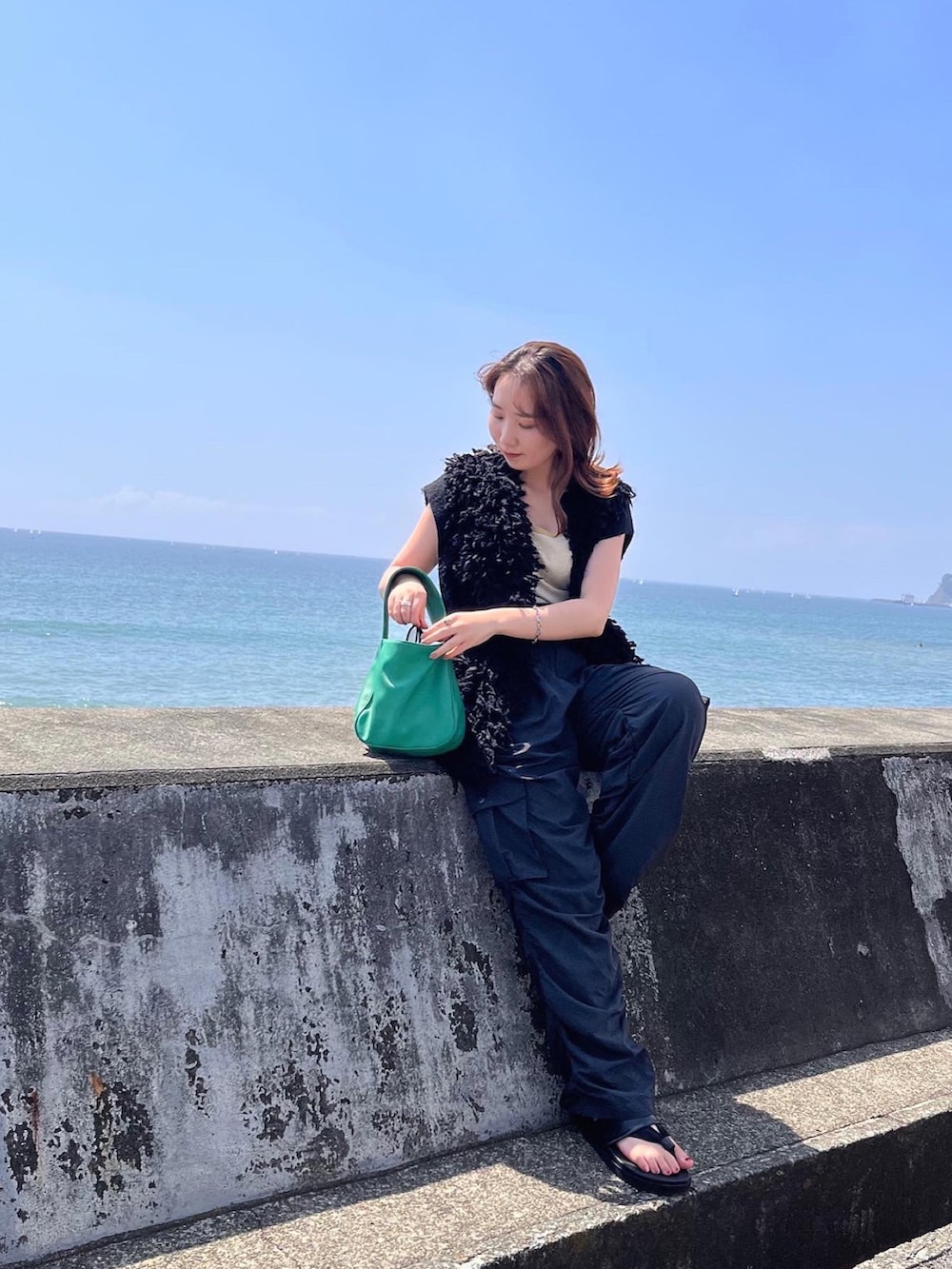 ブラック系のその他パンツ、ブラック系のベスト、イエロー系のタンクトップを着用したレディースの秋コーディネートの3枚目の写真