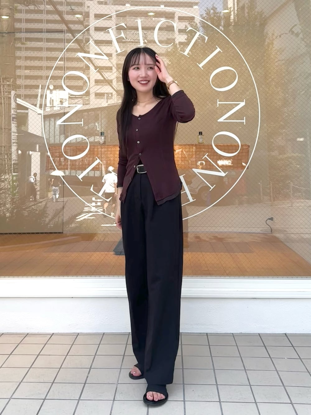 ブラック系のスラックス、レッド系のTシャツ/カットソー、ブラック系のサンダルを着用したレディースの秋コーディネートの2枚目の写真