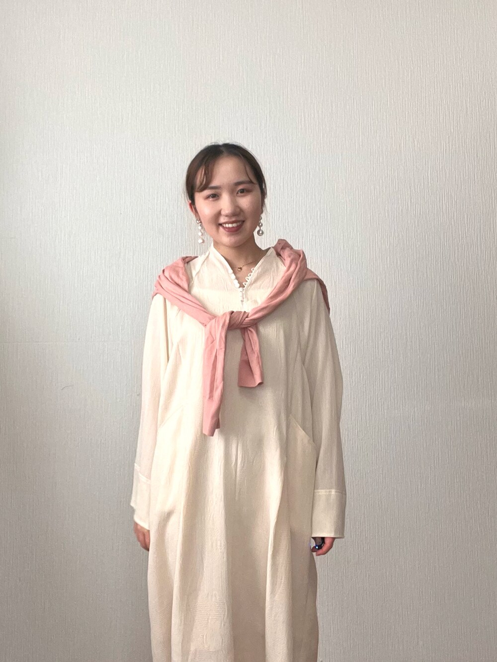 ホワイト系のワンピース、ピンク系のカーディガン/ボレロ、ベージュ系のサンダルを着用したレディースの秋コーディネートの5枚目の写真