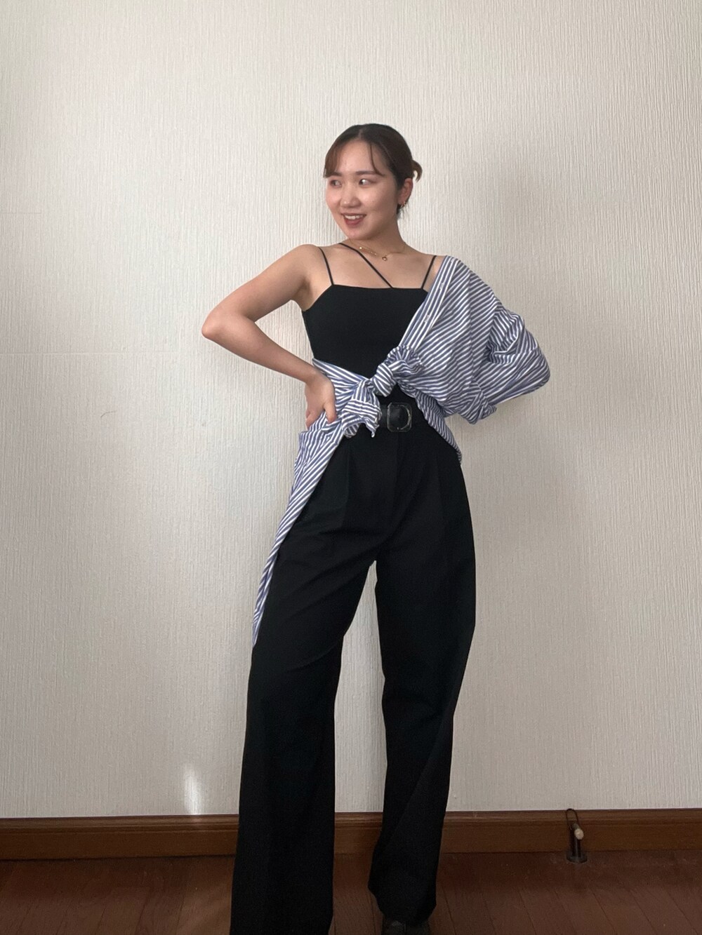 ブルー系のシャツ/ブラウス、ブラック系のデニムパンツ、ブラック系のサンダルを着用したレディースの秋コーディネートの2枚目の写真