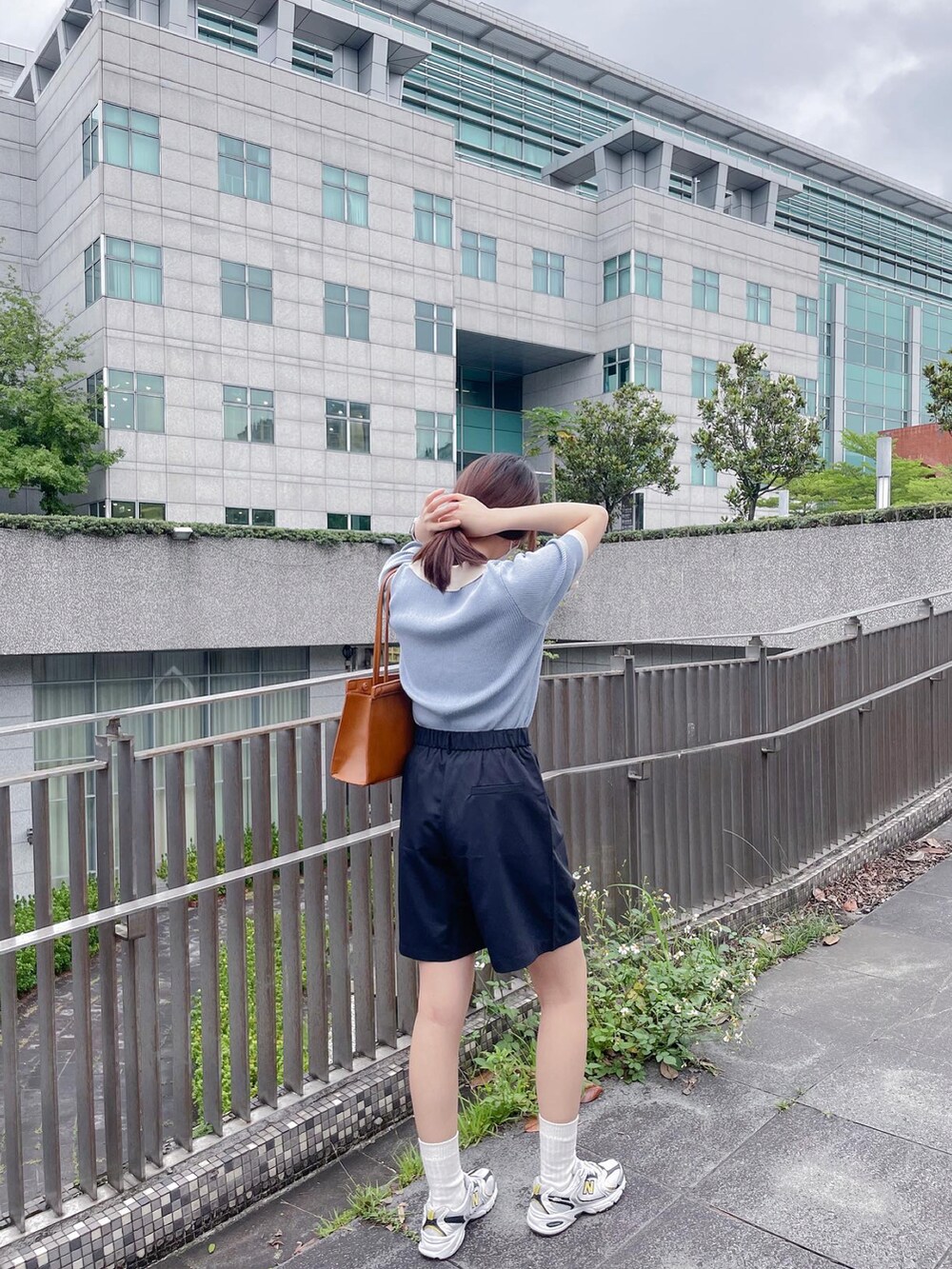 ホワイト系のスニーカー、ブラウン系のショルダーバッグを着用したレディースの夏コーディネートの3枚目の写真