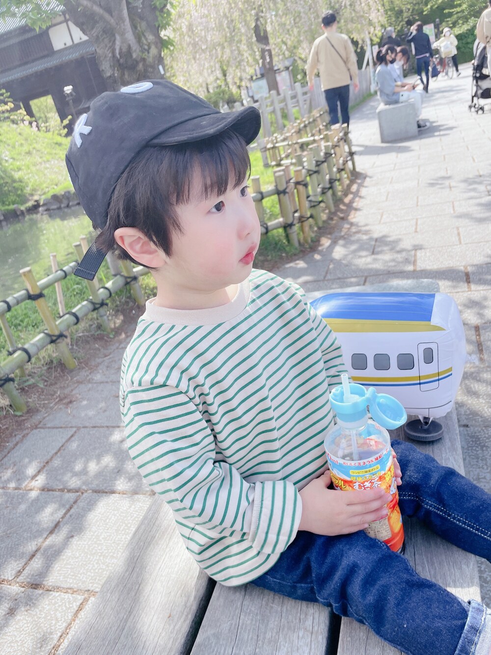 ベージュ系のTシャツ/カットソー、ブルー系のデニムパンツ、ブラック系のキャップを着用したキッズの春コーディネートの3枚目の写真