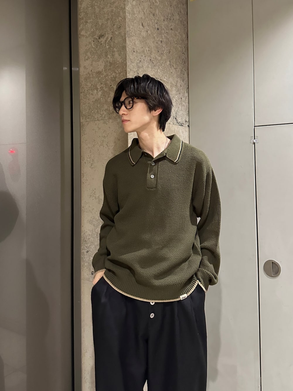 グリーン系のポロシャツ、ブラウン系のブーツを着用したメンズの秋コーディネートの2枚目の写真