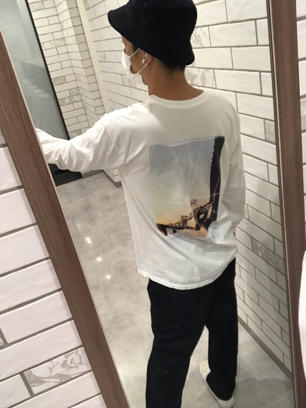 ホワイト系のビジネスシャツ、ベージュ系のスニーカー、ブラック系のハットを着用したメンズの冬コーディネートの2枚目の写真