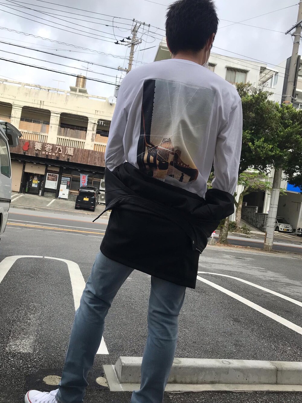 ホワイト系のTシャツ/カットソー、ブルー系のデニムパンツ、ホワイト系のスニーカーを着用したメンズの冬コーディネートの2枚目の写真