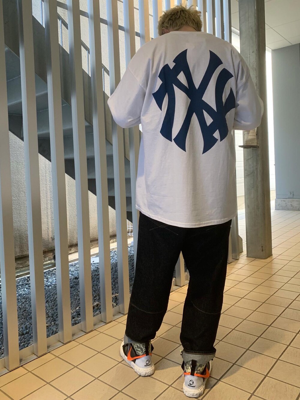 ホワイト系のTシャツ/カットソー、ブルー系のデニムパンツを着用したメンズの冬コーディネートの2枚目の写真