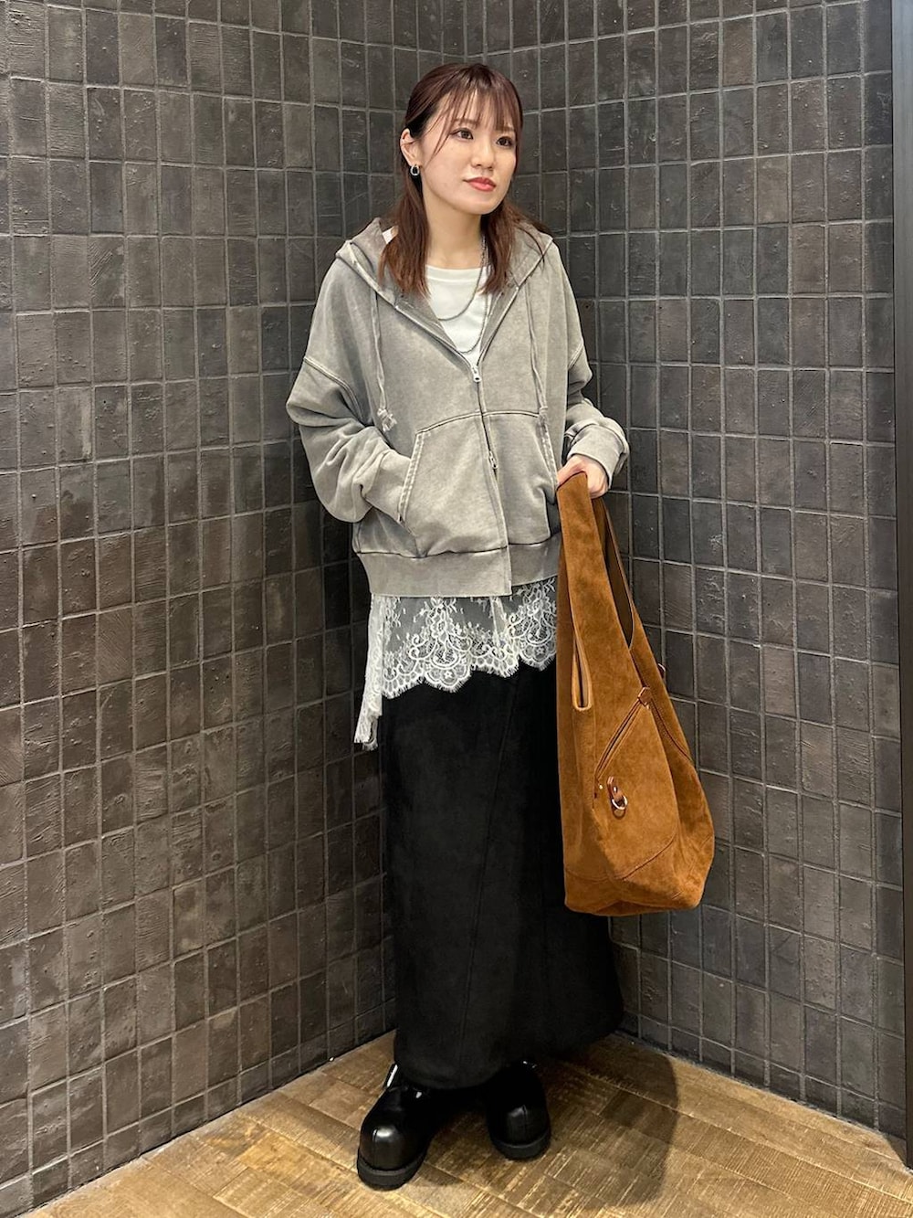 グレー系のパーカー、ブラック系のその他シューズ、ブラック系のスカートを着用したレディースの秋コーディネートの4枚目の写真