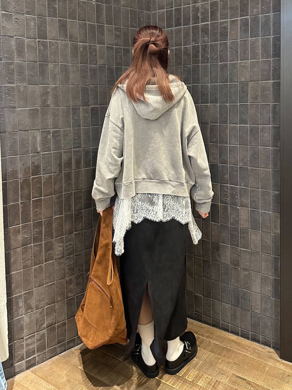 グレー系のパーカー、ブラック系のその他シューズ、ブラック系のスカートを着用したレディースの秋コーディネートの3枚目の写真
