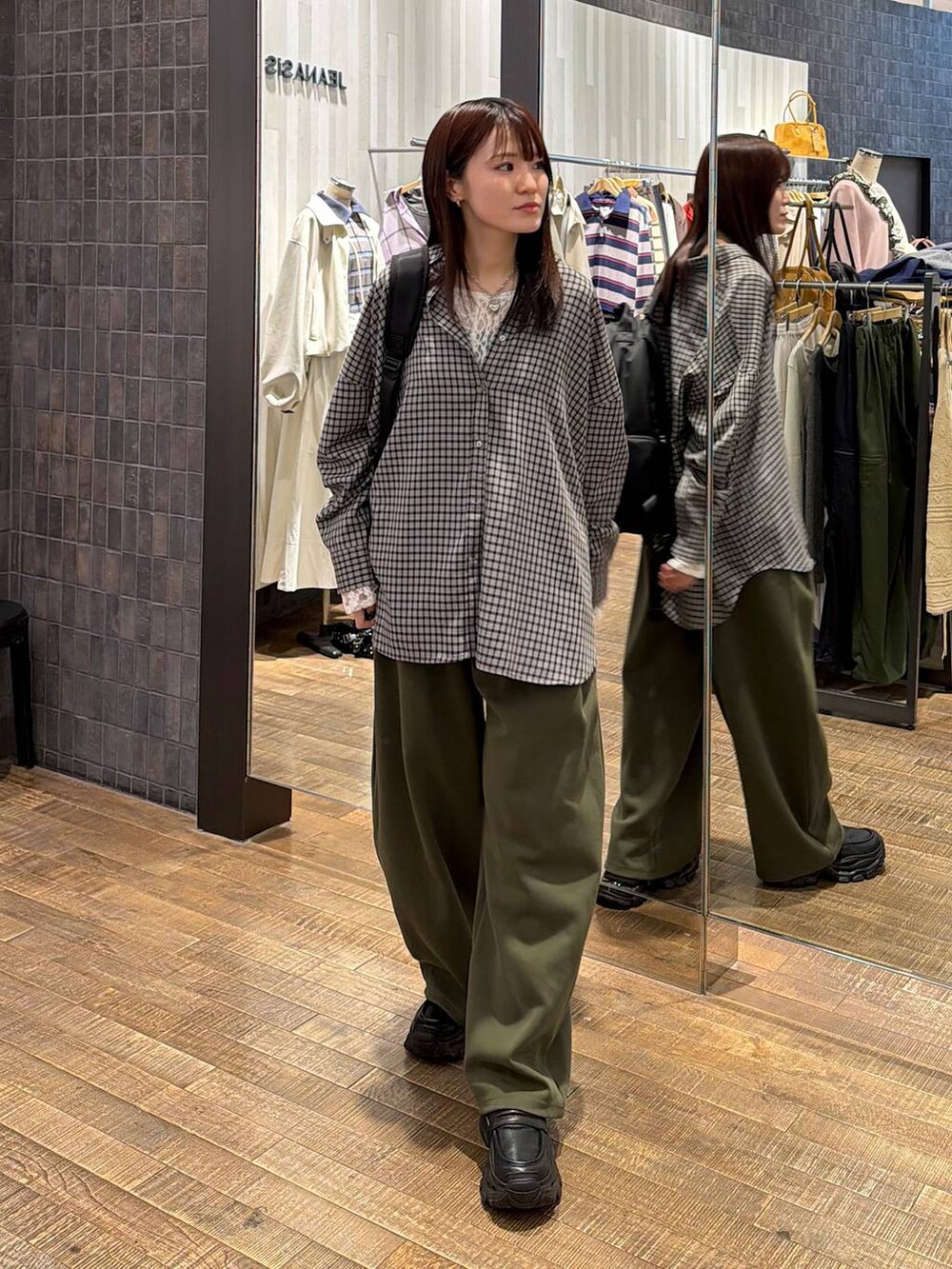 ブラック系のシャツ/ブラウス、ブラック系のローファー、グリーン系のスウェットパンツを着用したレディースの冬コーディネートの4枚目の写真