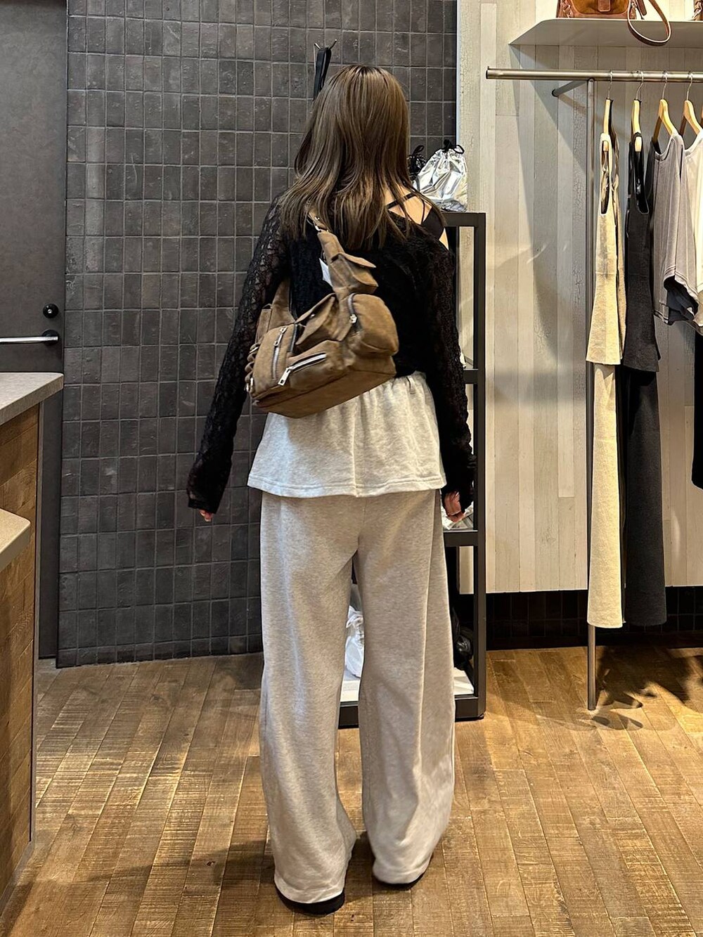 ブラウン系のショルダーバッグ、グレー系のスウェットパンツ、ブラック系のサンダルを着用したレディースの夏コーディネートの3枚目の写真