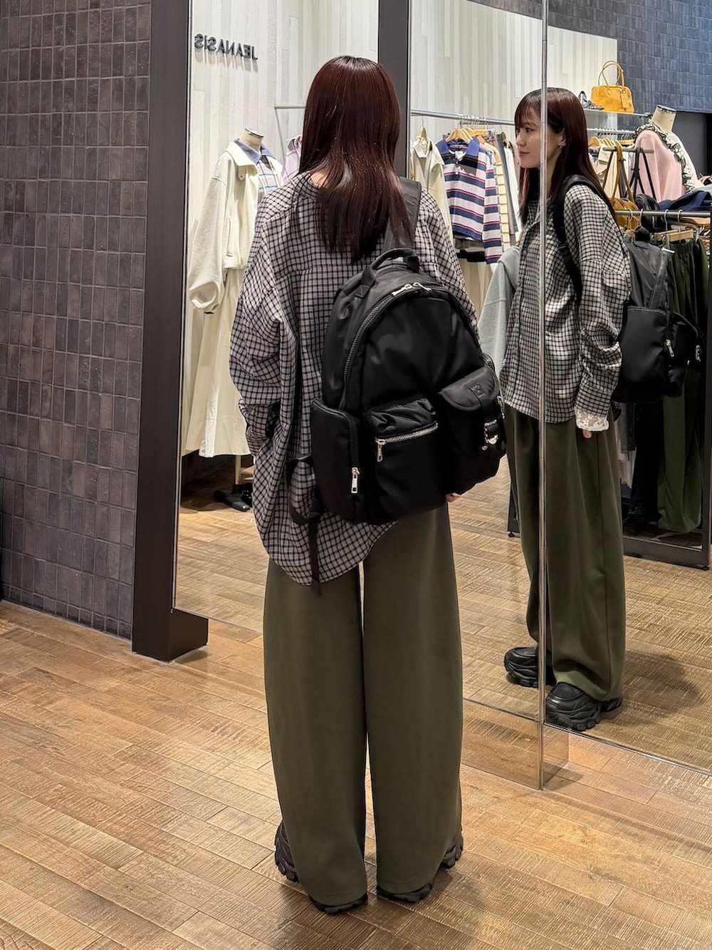 ブラック系のシャツ/ブラウス、ブラック系のローファー、グリーン系のスウェットパンツを着用したレディースの冬コーディネートの3枚目の写真