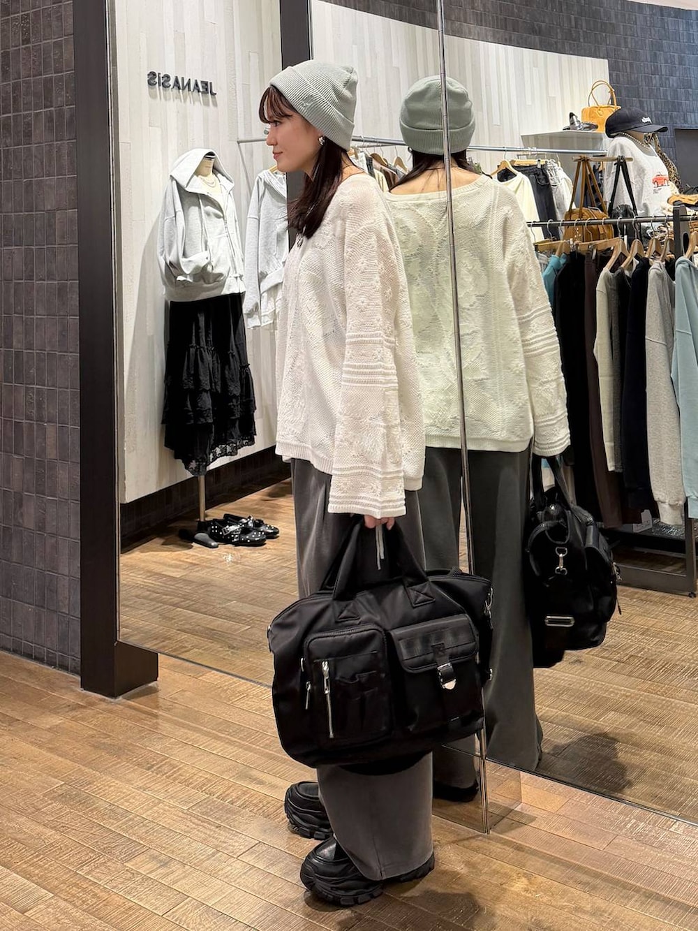 ブラック系のローファー、ブラック系のトートバッグ、ホワイト系のニット/セーターを着用したレディースの冬コーディネートの2枚目の写真