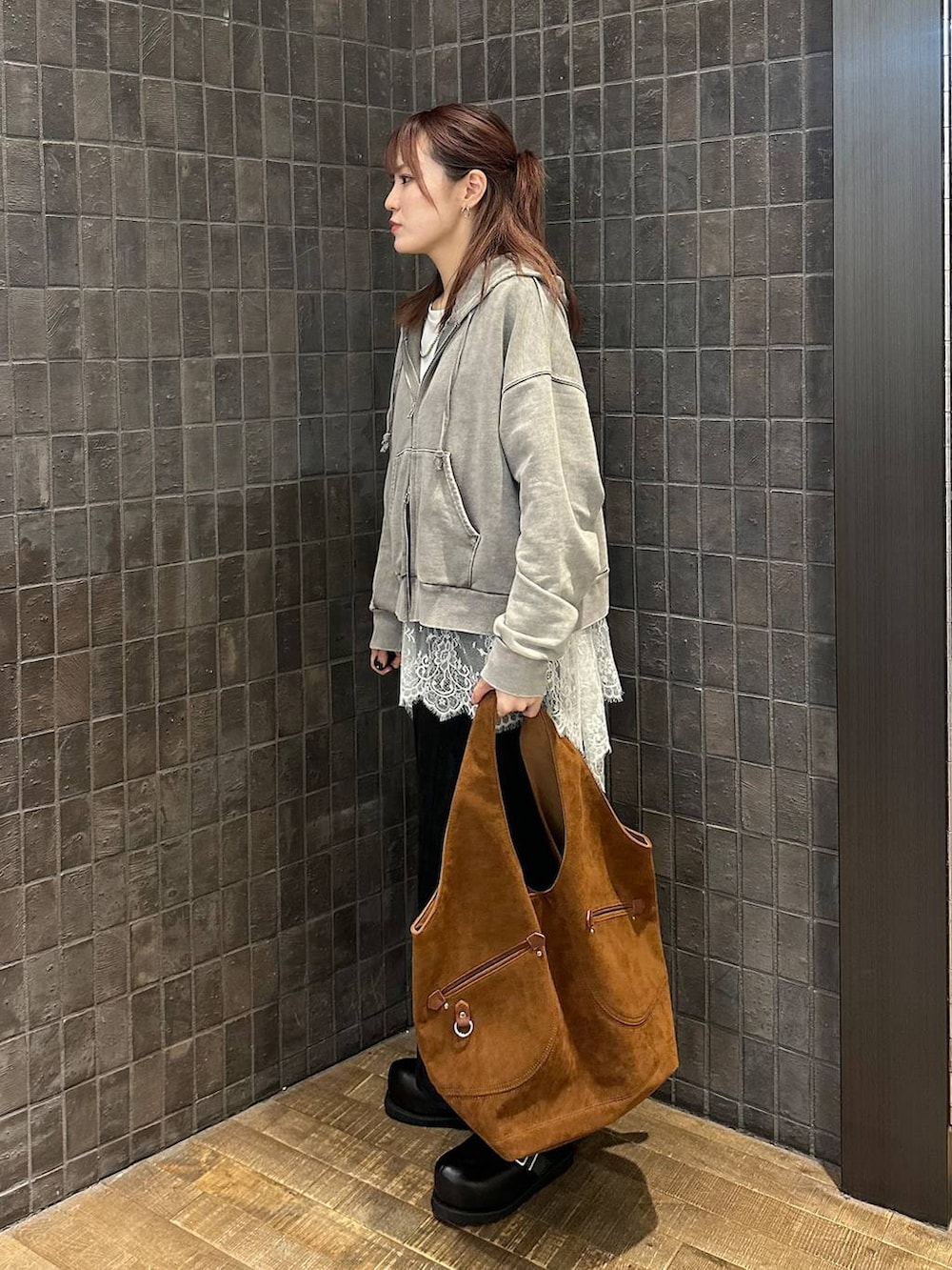 グレー系のパーカー、ブラック系のその他シューズ、ブラック系のスカートを着用したレディースの秋コーディネートの2枚目の写真