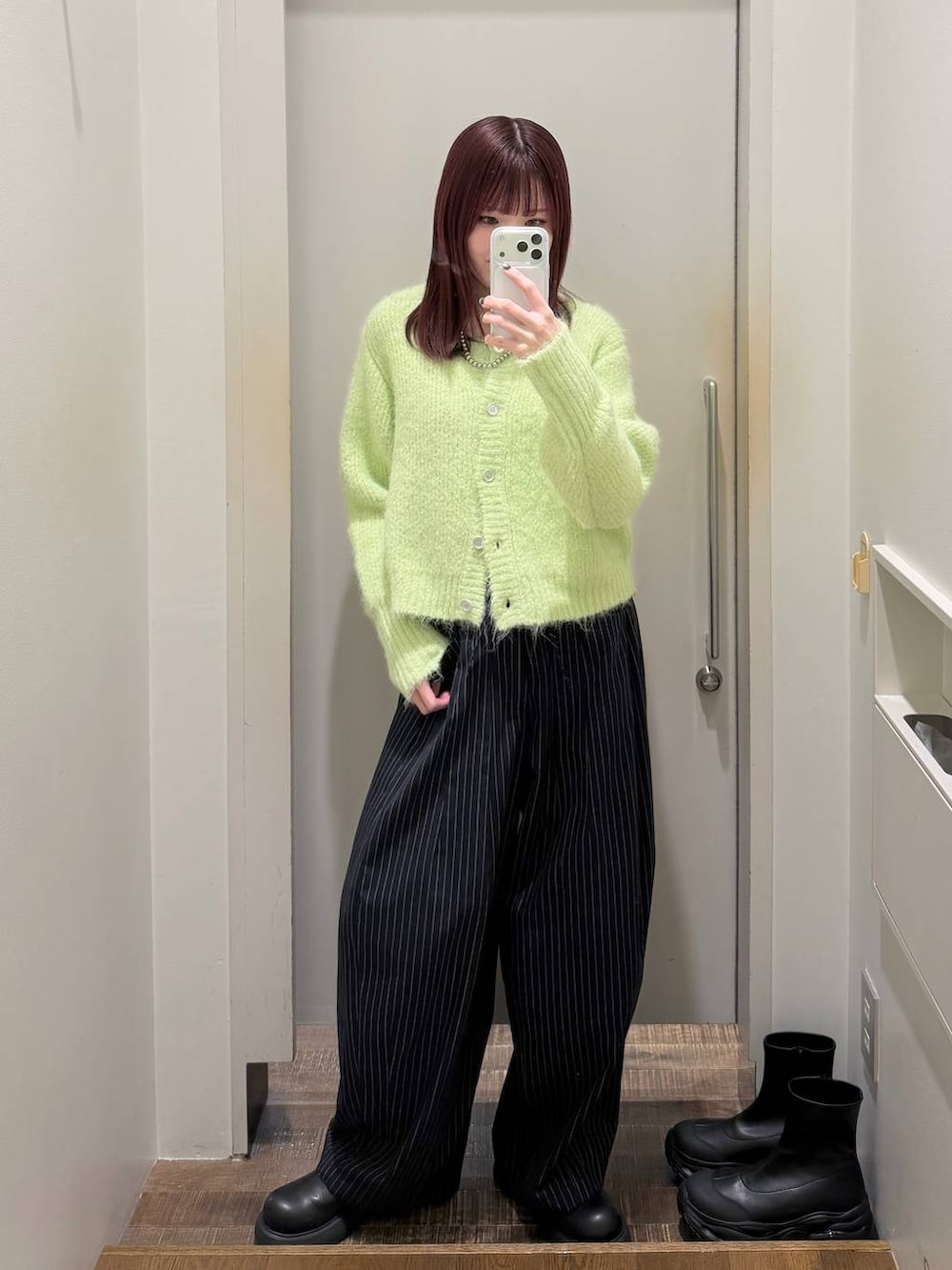 ブラック系のサンダル、ブルー系のスラックス、グリーン系のカーディガン/ボレロを着用したレディースの冬コーディネートの2枚目の写真