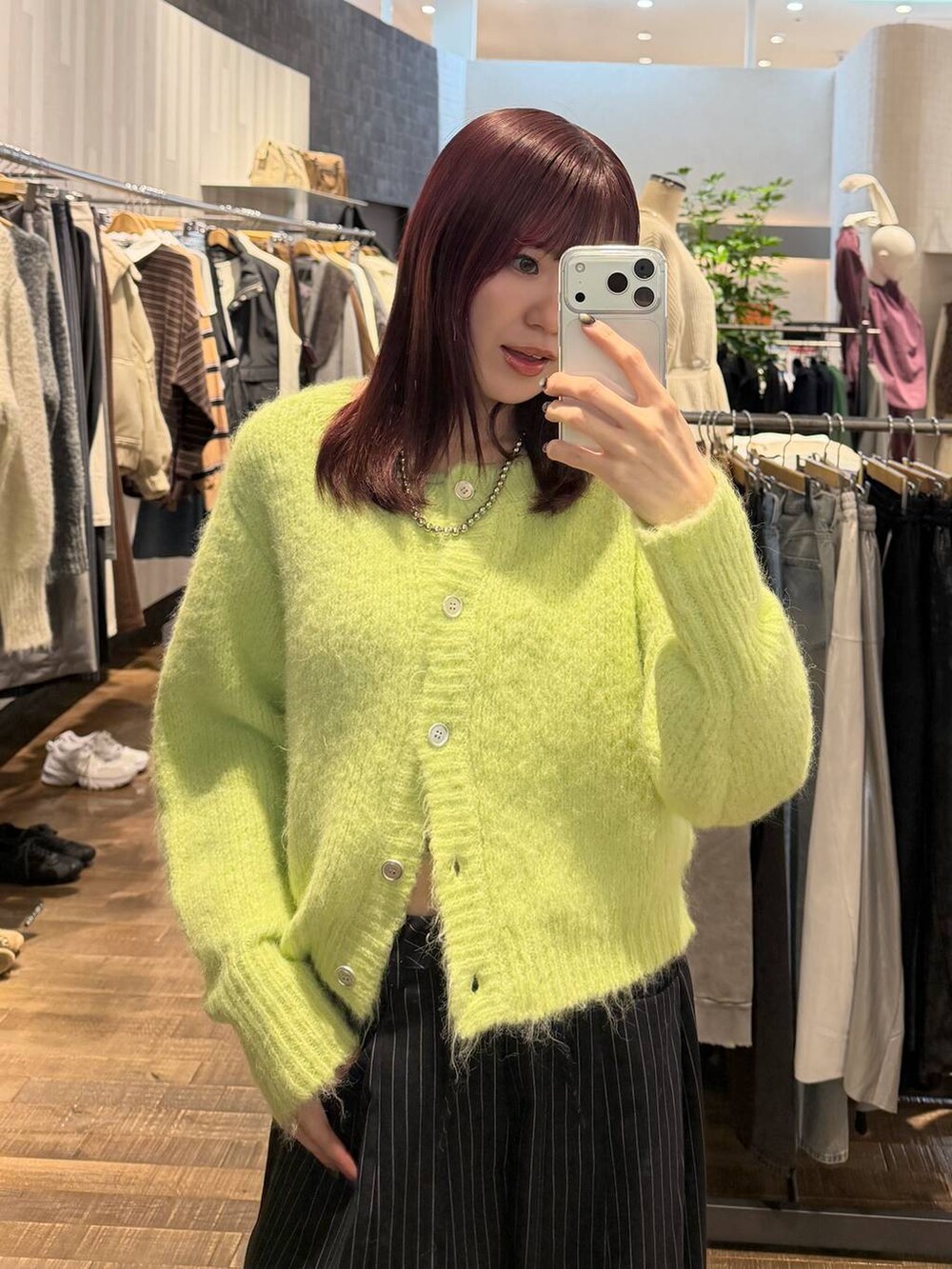 ブラック系のサンダル、ブルー系のスラックス、グリーン系のカーディガン/ボレロを着用したレディースの冬コーディネートの3枚目の写真