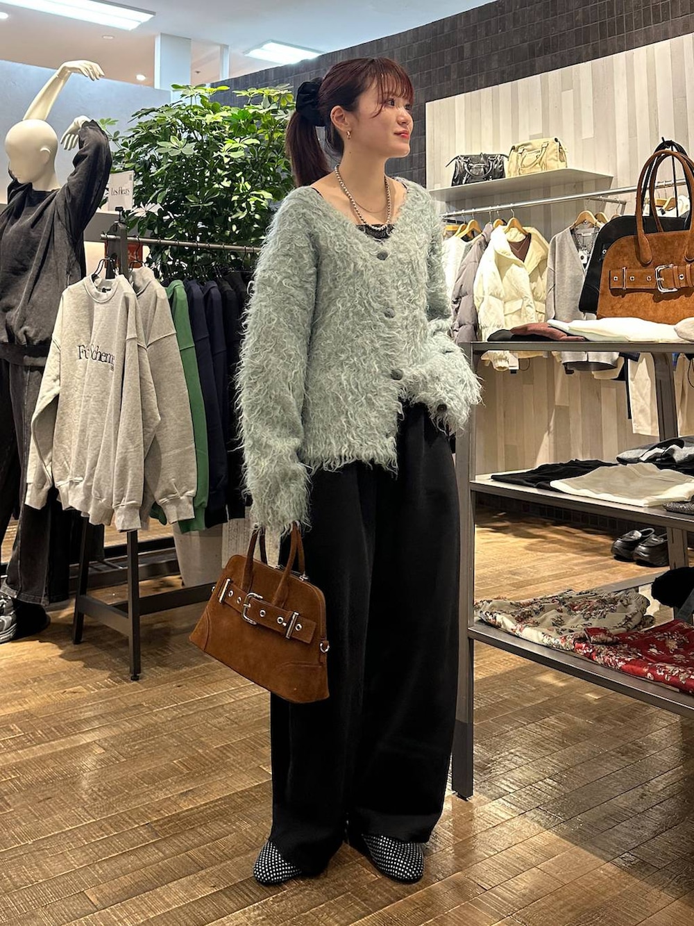 ブラック系のパンプス、ブラウン系のボストンバッグ、ブラック系のスウェットパンツを着用したレディースの冬コーディネートの4枚目の写真