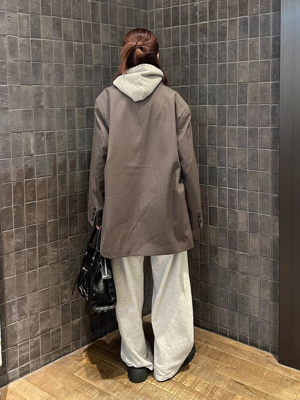 ブラック系のサンダル、グレー系のパーカー、ブラック系のボストンバッグを着用したレディースの秋コーディネートの3枚目の写真