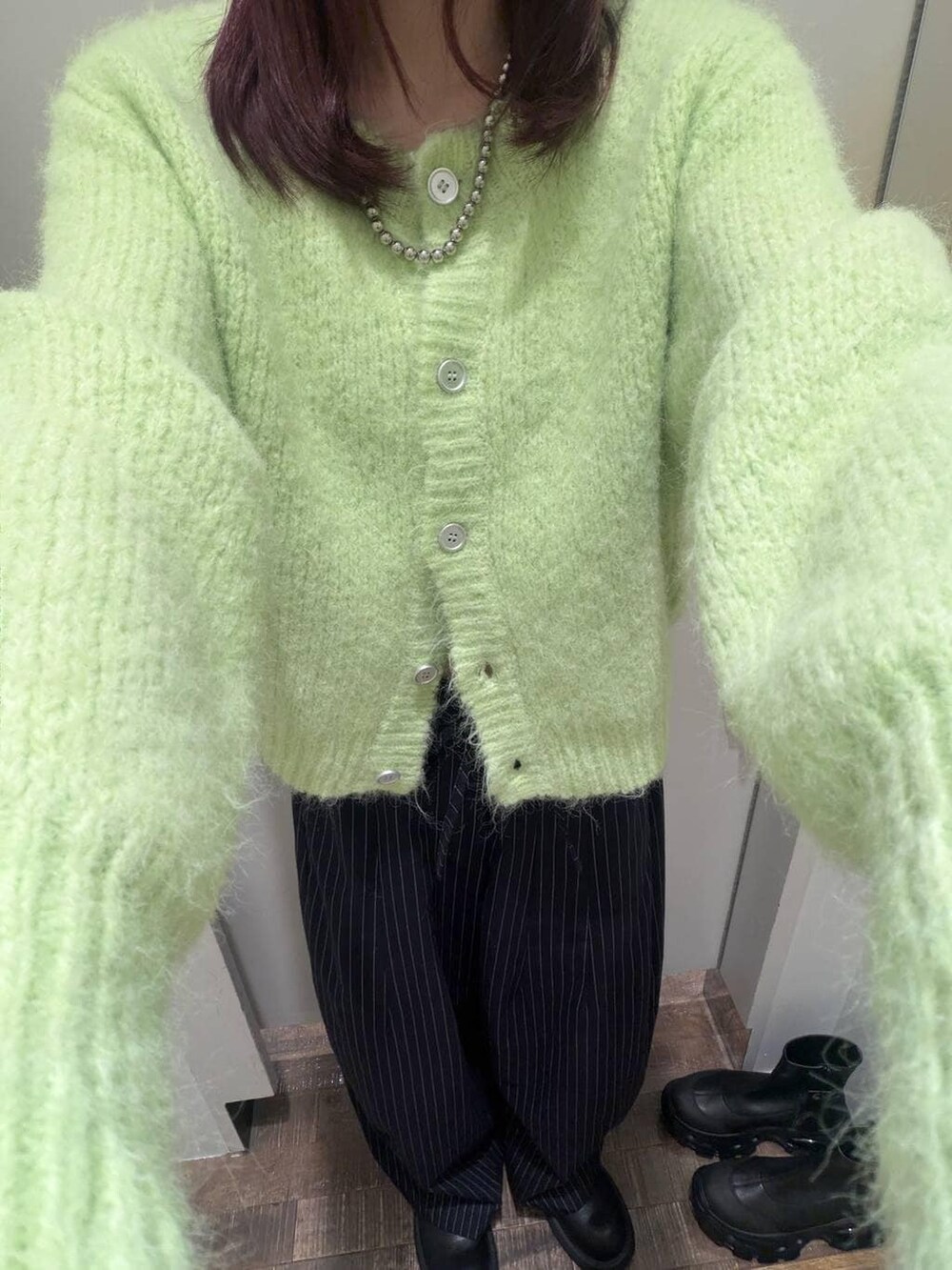 ブラック系のサンダル、ブルー系のスラックス、グリーン系のカーディガン/ボレロを着用したレディースの冬コーディネートの4枚目の写真