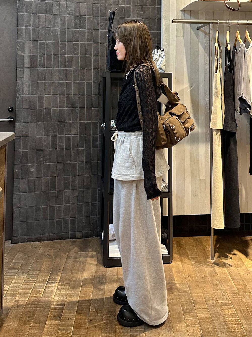 ブラウン系のショルダーバッグ、グレー系のスウェットパンツ、ブラック系のサンダルを着用したレディースの夏コーディネートの2枚目の写真