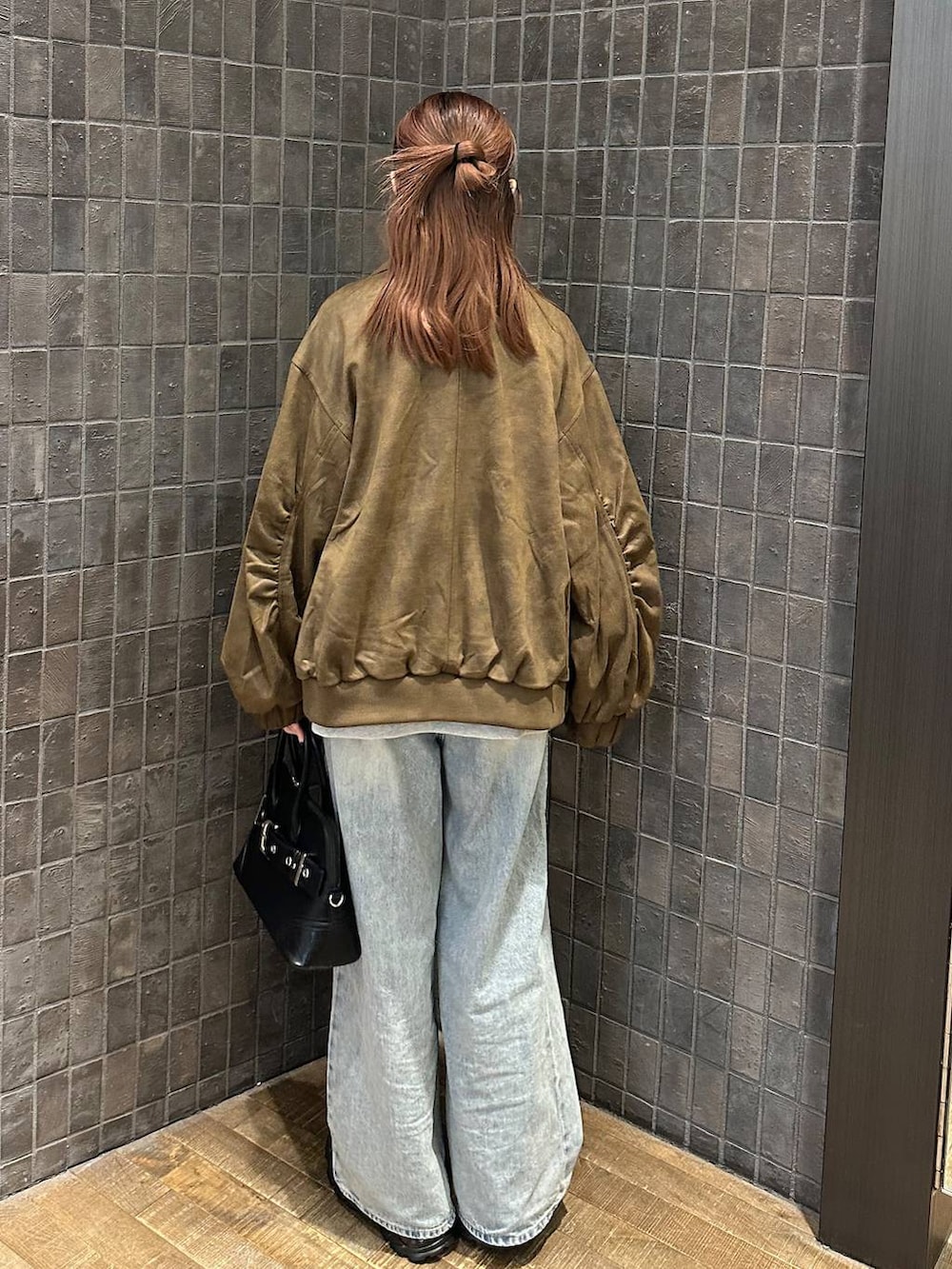 ブルー系のデニムパンツ、ブラウン系のブルゾン、ブラック系のローファーを着用したレディースの秋コーディネートの3枚目の写真