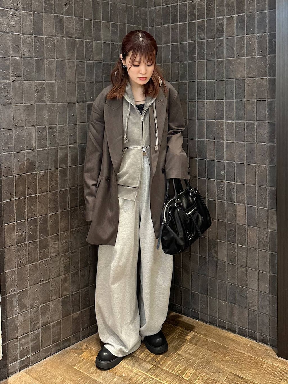 ブラック系のサンダル、グレー系のパーカー、ブラック系のボストンバッグを着用したレディースの秋コーディネートの4枚目の写真