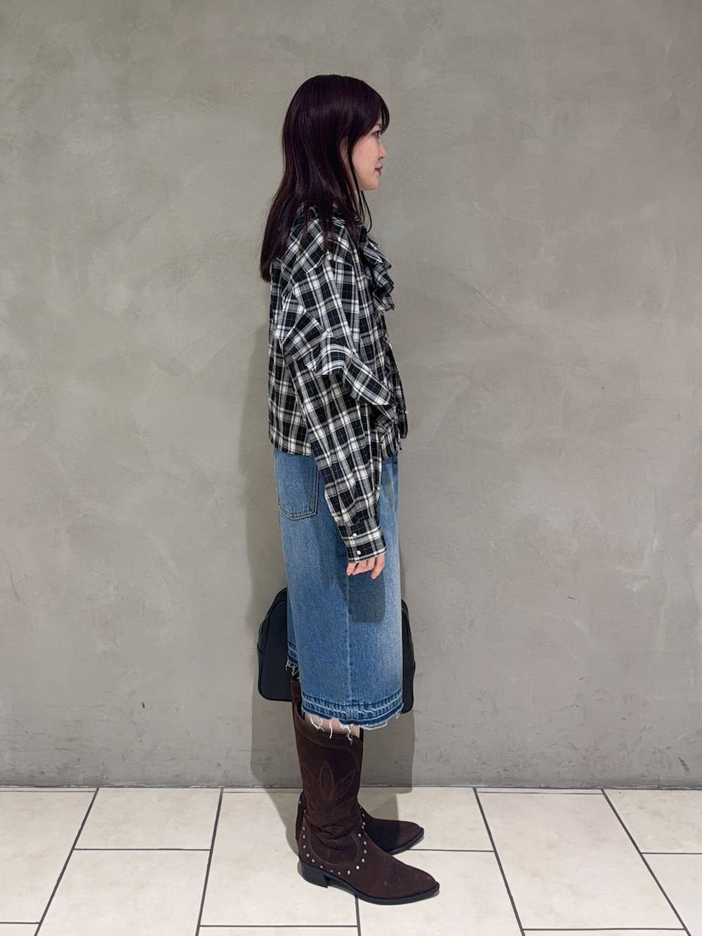 ブラック系のボストンバッグ、ブラウン系のブーツ、ブラック系のシャツ/ブラウスを着用したレディースの春コーディネートの2枚目の写真