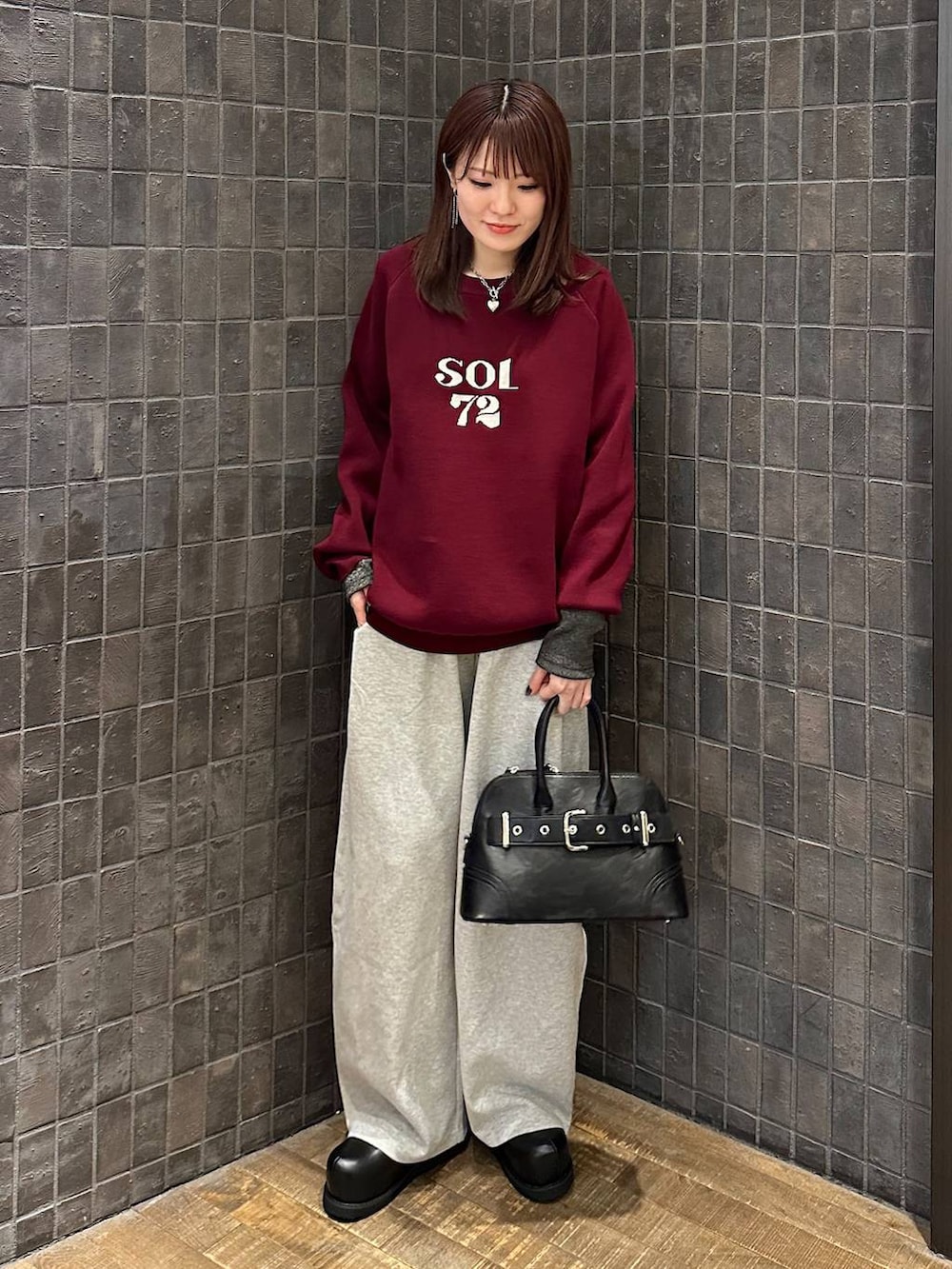 ブラック系のTシャツ/カットソー、ブラック系のその他シューズ、グレー系のスウェットパンツを着用したレディースの秋コーディネートの4枚目の写真