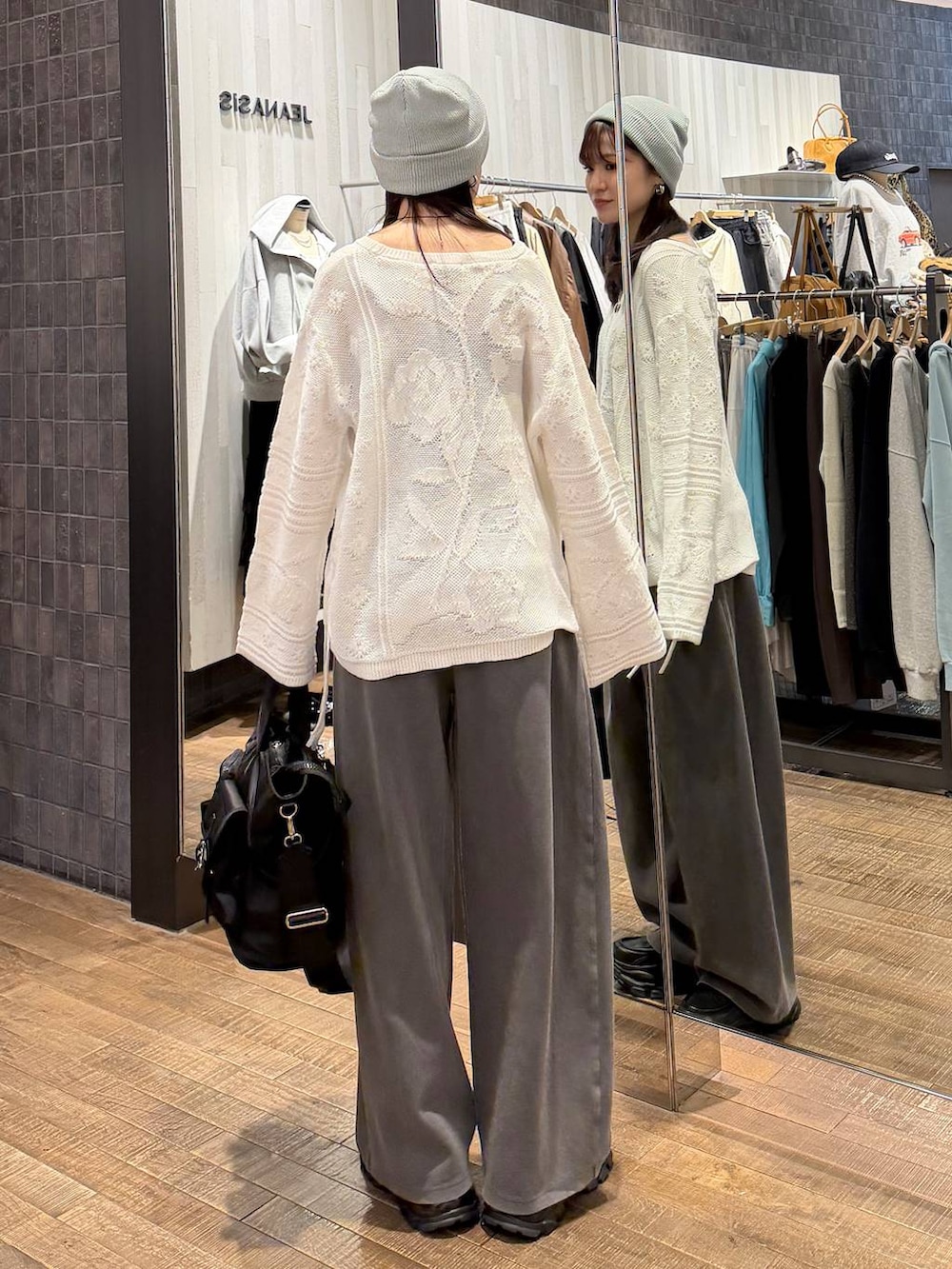 ブラック系のローファー、ブラック系のトートバッグ、ホワイト系のニット/セーターを着用したレディースの冬コーディネートの3枚目の写真