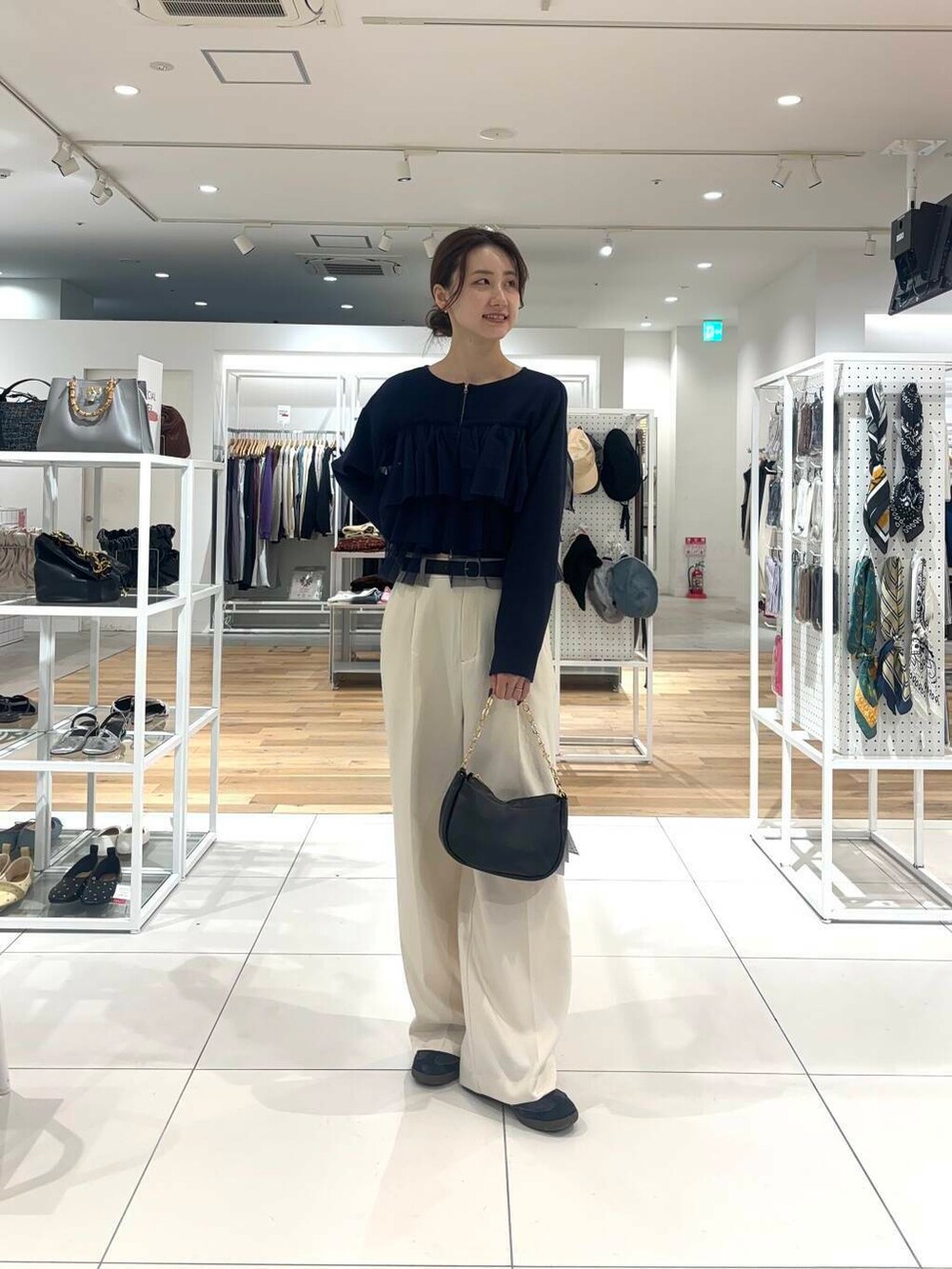 ホワイト系のその他パンツ、ブラック系のショルダーバッグ、ブルー系のニット/セーターを着用したレディースの秋コーディネートの2枚目の写真