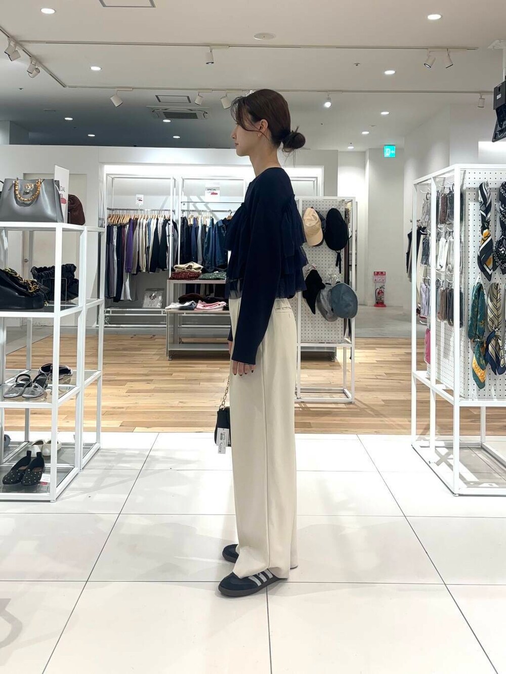 ホワイト系のその他パンツ、ブラック系のショルダーバッグ、ブルー系のニット/セーターを着用したレディースの秋コーディネートの3枚目の写真