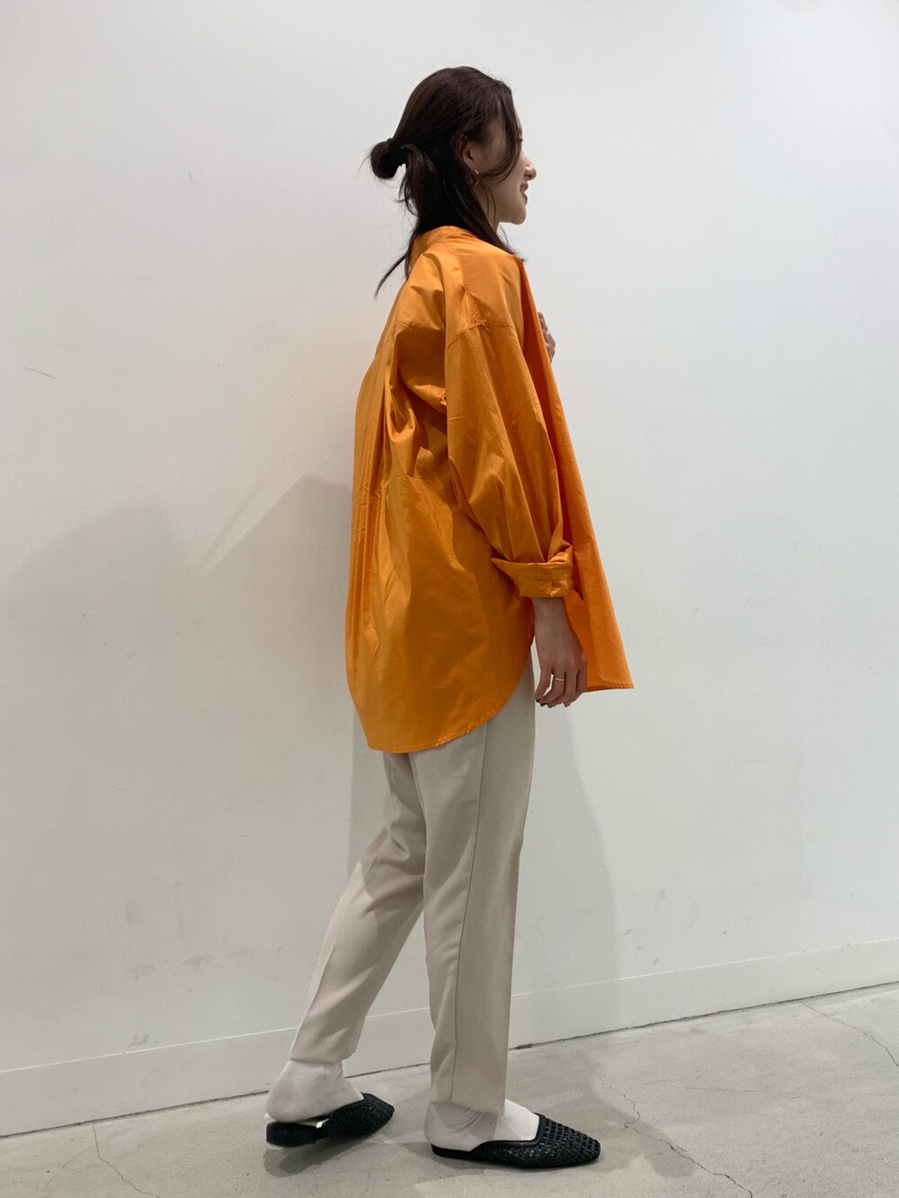 オレンジ系のシャツ/ブラウス、ベージュ系のその他パンツ、ブラウン系のトートバッグを着用したレディースの春コーディネートの2枚目の写真