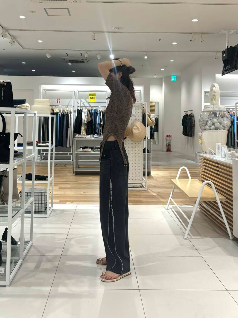 ブラック系のデニムパンツ、ブラウン系のニット/セーターを着用したレディースの夏コーディネートの3枚目の写真