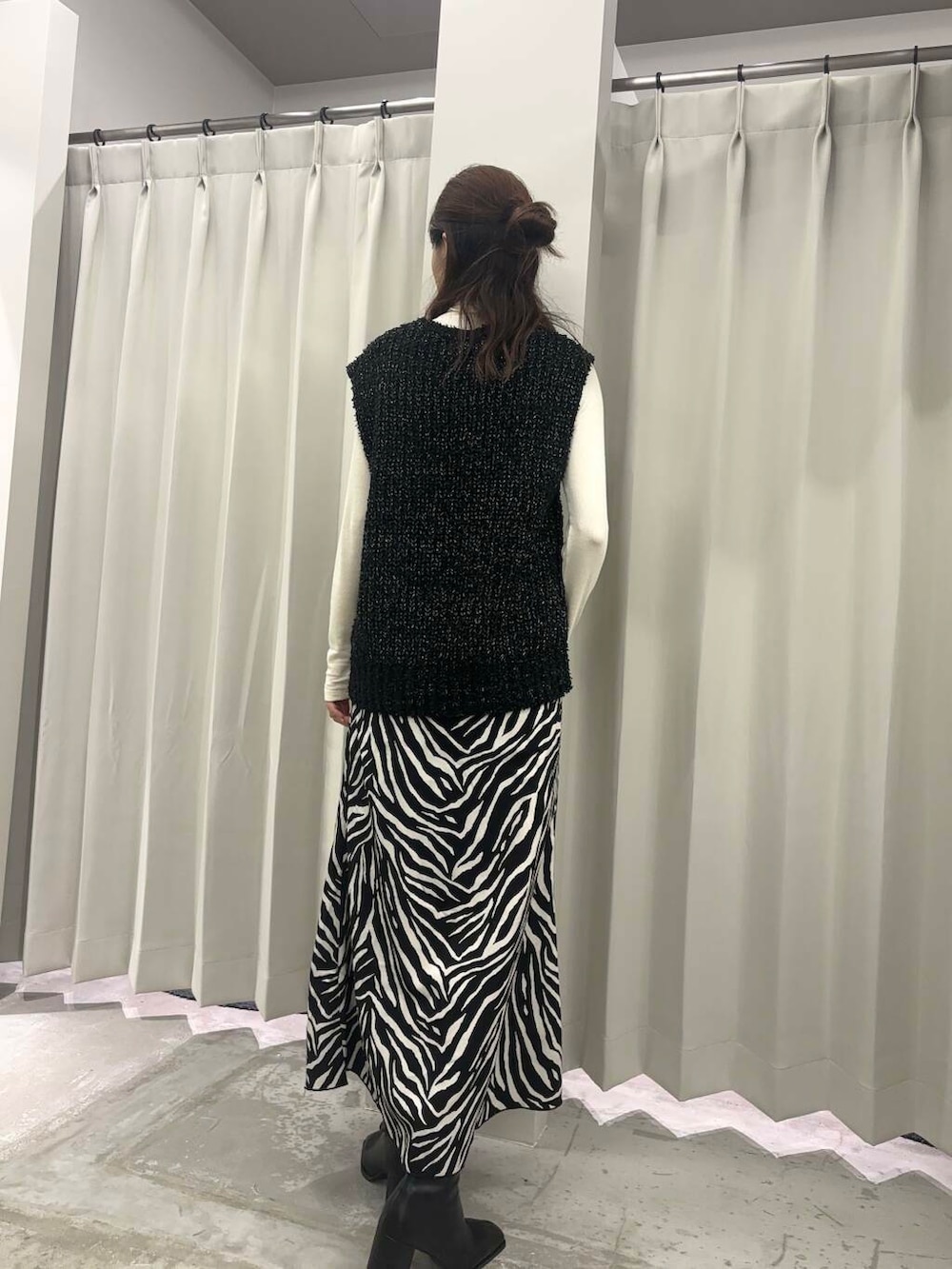 ブラック系のベスト、ブラック系のブーツ、ホワイト系のTシャツ/カットソーを着用したレディースの秋コーディネートの3枚目の写真