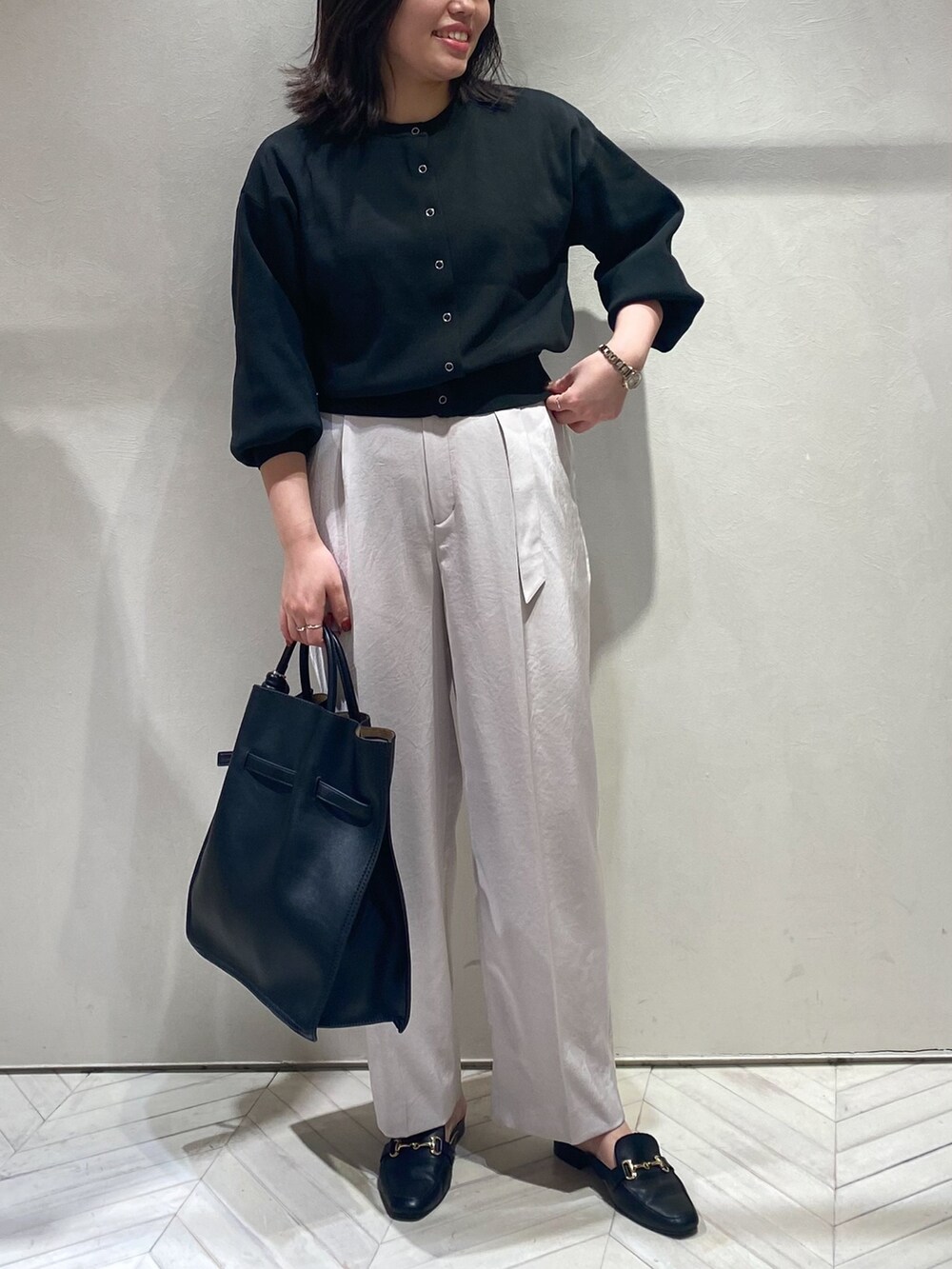 ブラック系のカーディガン/ボレロ、ピンク系のスラックス、ブラック系のトートバッグを着用したレディースの秋コーディネートの4枚目の写真