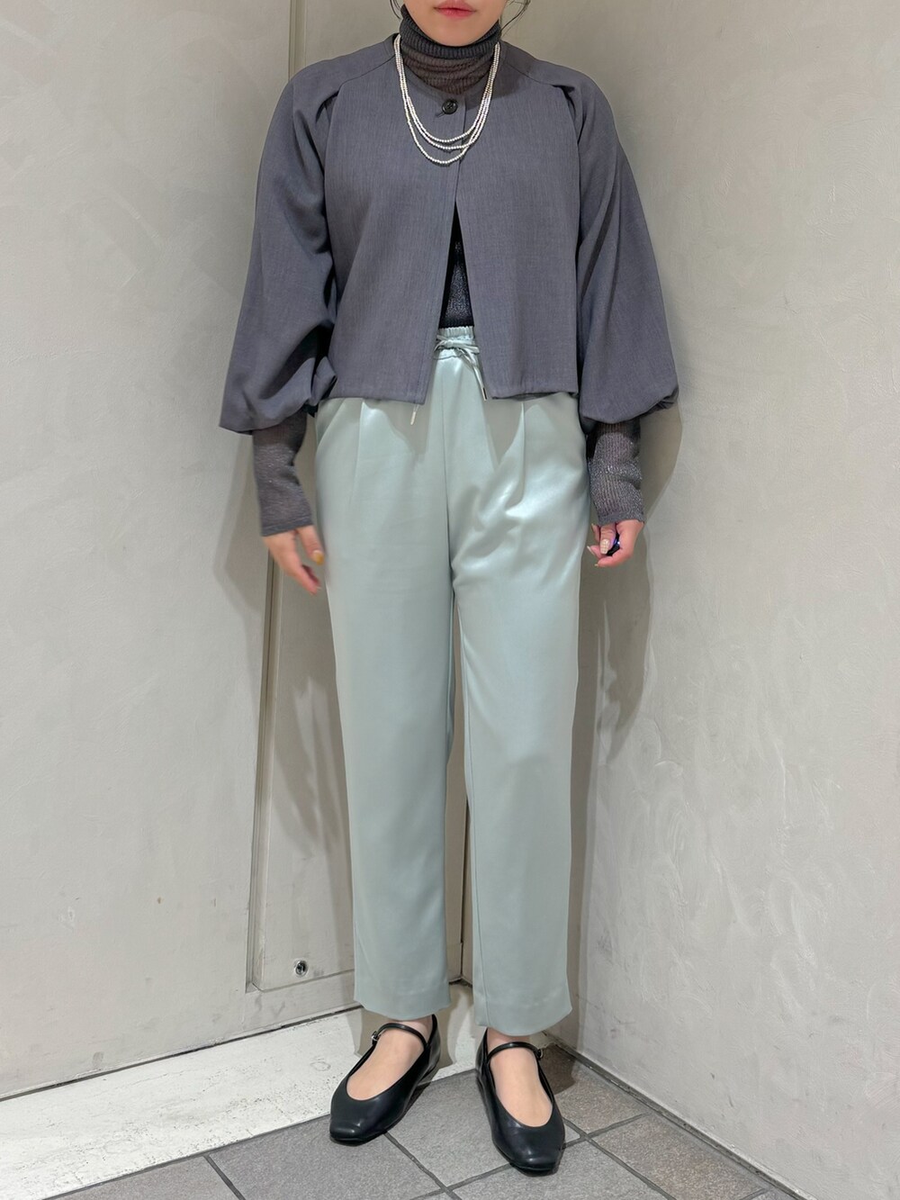 グリーン系のスラックス、グレー系のニット/セーター、グレー系のテーラードジャケットを着用したレディースの秋コーディネートの7枚目の写真