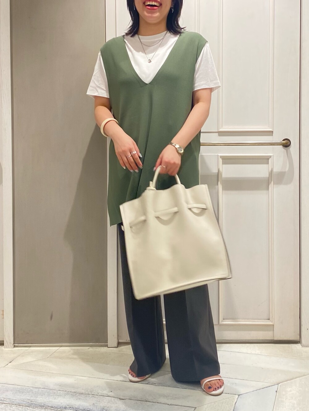 グリーン系のベスト、ホワイト系のTシャツ/カットソー、ホワイト系のトートバッグを着用したレディースの夏コーディネートの3枚目の写真