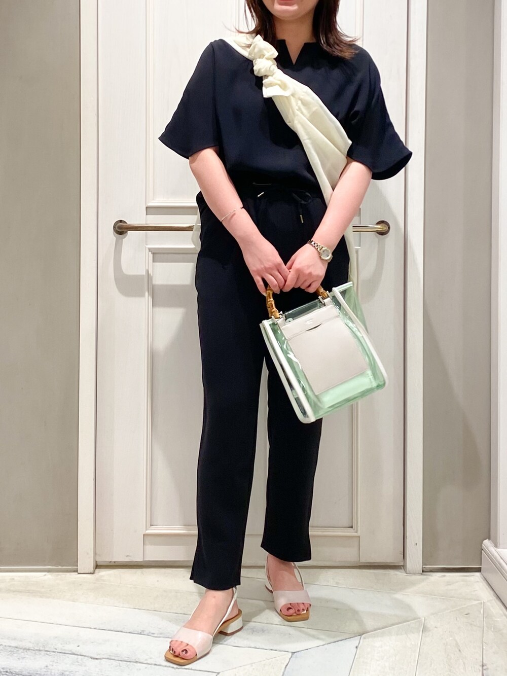 ブラック系のTシャツ/カットソー、ブラック系のスラックス、ホワイト系のトートバッグを着用したレディースの夏コーディネートの3枚目の写真