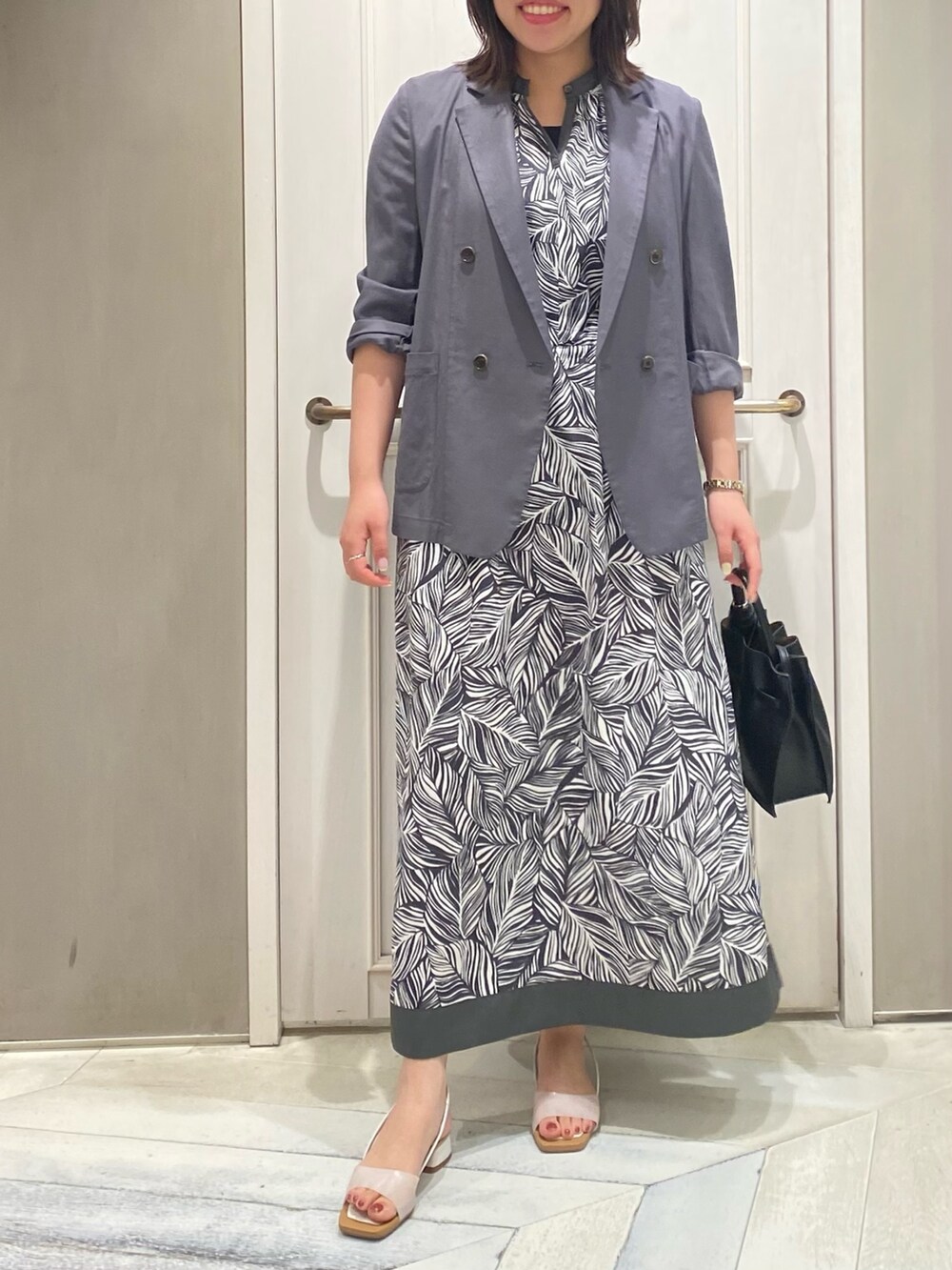 グレー系のワンピース、グレー系のテーラードジャケット、グリーン系のトートバッグを着用したレディースの夏コーディネートの2枚目の写真
